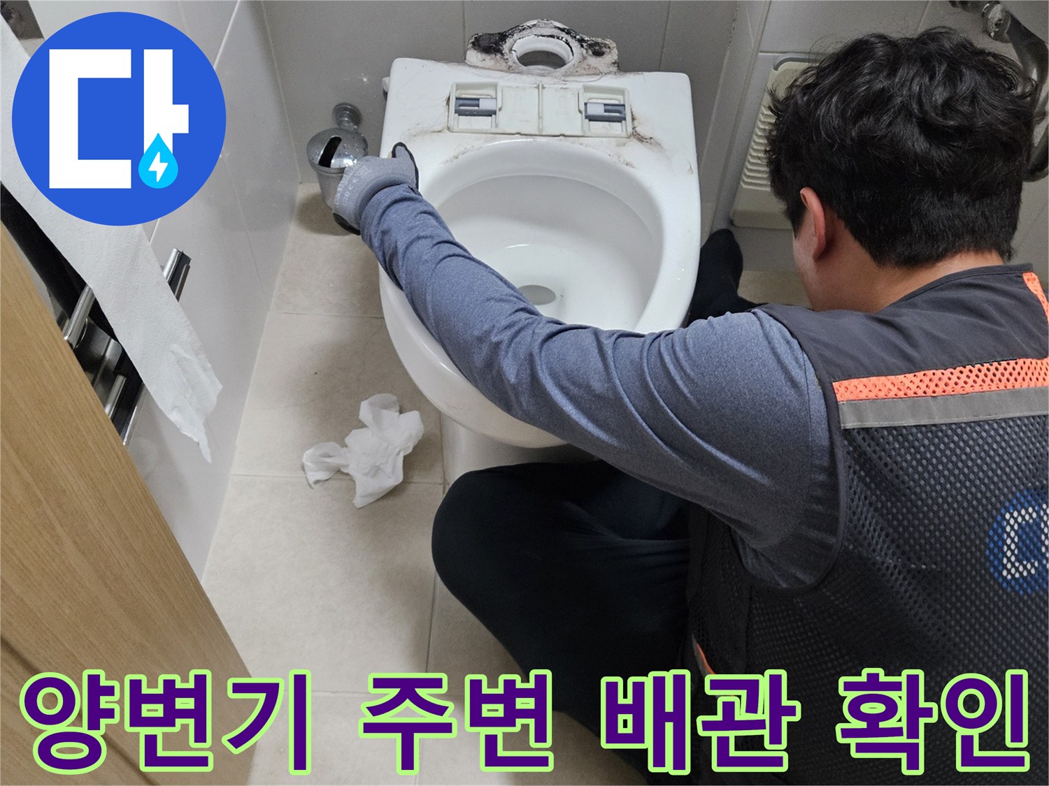 양변기 하단부 배관 연결 상태를 면밀히 관찰하는 작업자