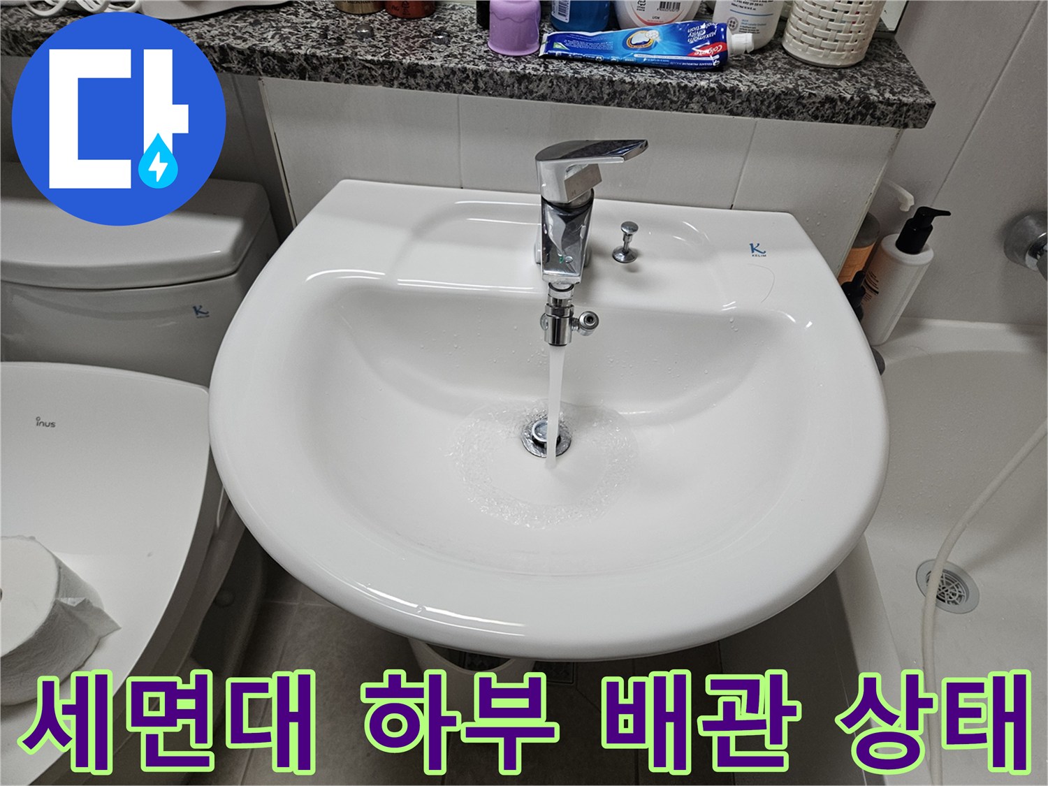 화장실 세면대 하부에 연결된 수전과 배관의 외관을 촬영한 모습
