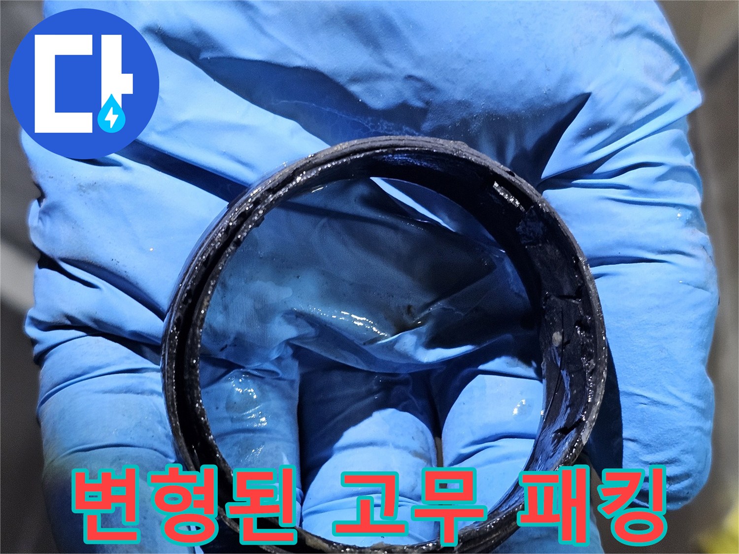 손가락 사이에 끼워져 있는 낡고 손상된 배관용 부속