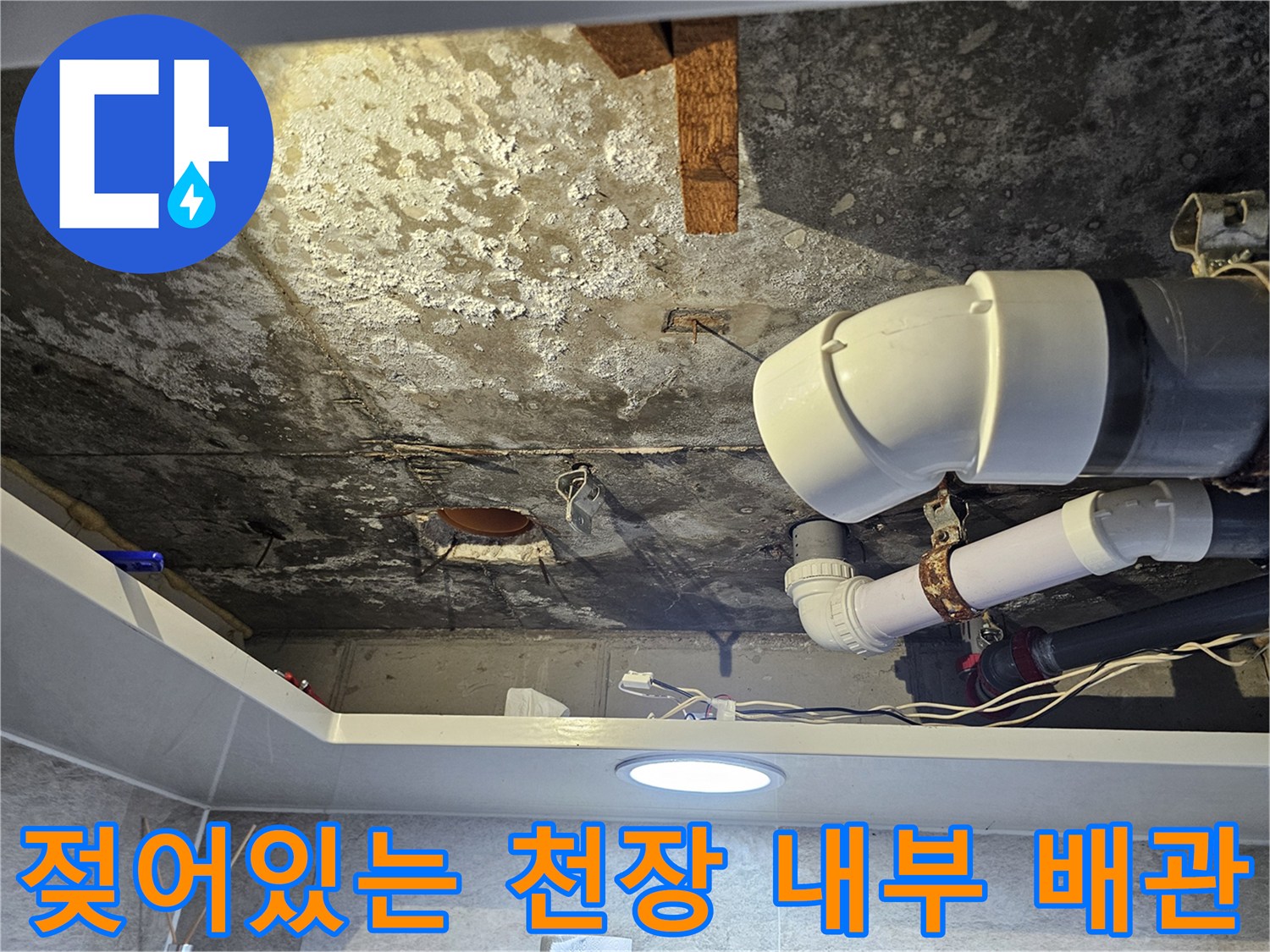 습기로 인해 얼룩이 생긴 화장실 천장 배관 주변의 모습