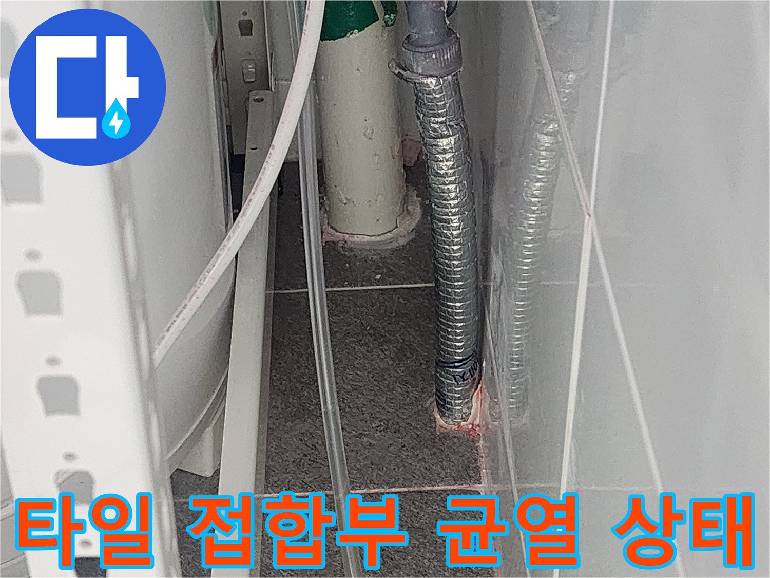 화장실 타일과 배관 사이의 균열된 틈새를 근접 촬영한 사진
