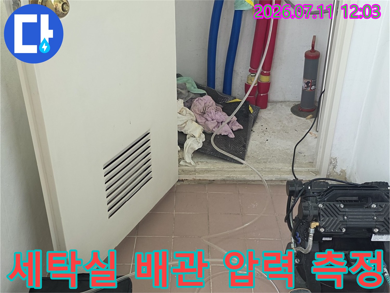 세탁실 공간 내에 설치된 보일러 배관의 기밀성을 확인하기 위한 장비 연결 모습