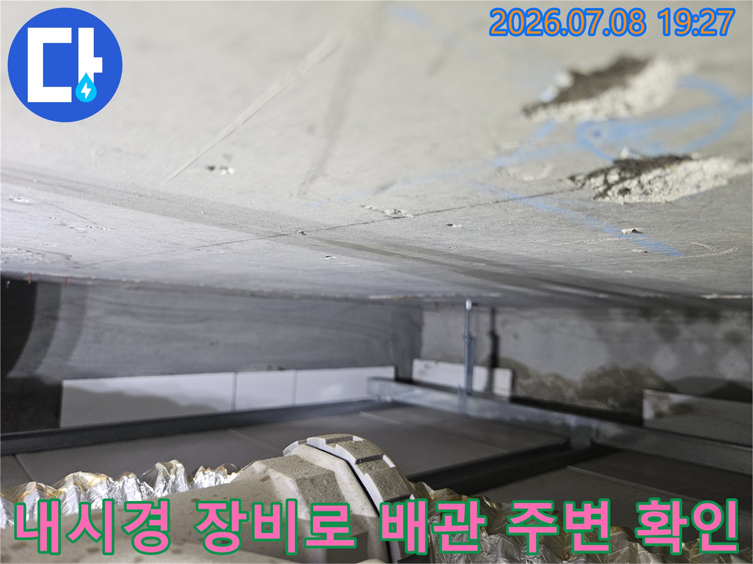 내시경 카메라를 통해 콘크리트 하부의 젖은 토양과 배관 상태를 실시간으로 모니터링하는 장면
