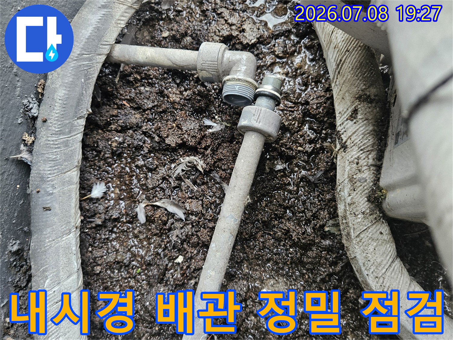 먼지 섞인 토사 내부에 노출된 회색 배관과 연결부 확인