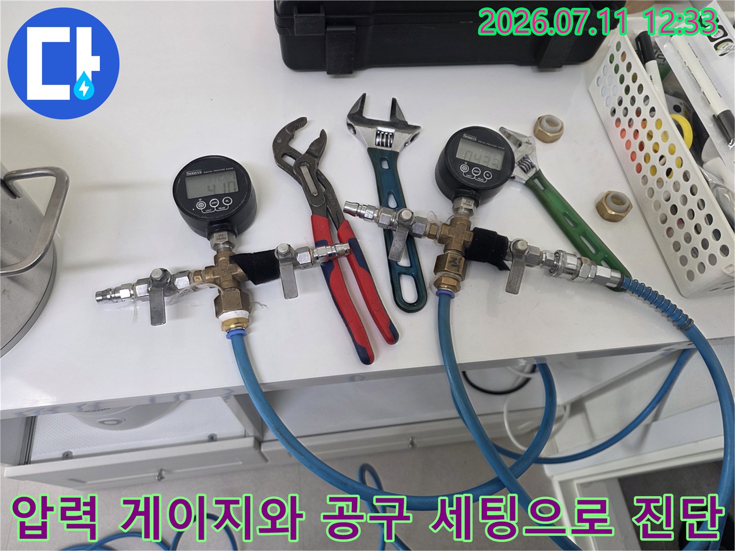 공압 측정 장치와 파란색 호스 및 렌치가 비치된 배관 점검 현장