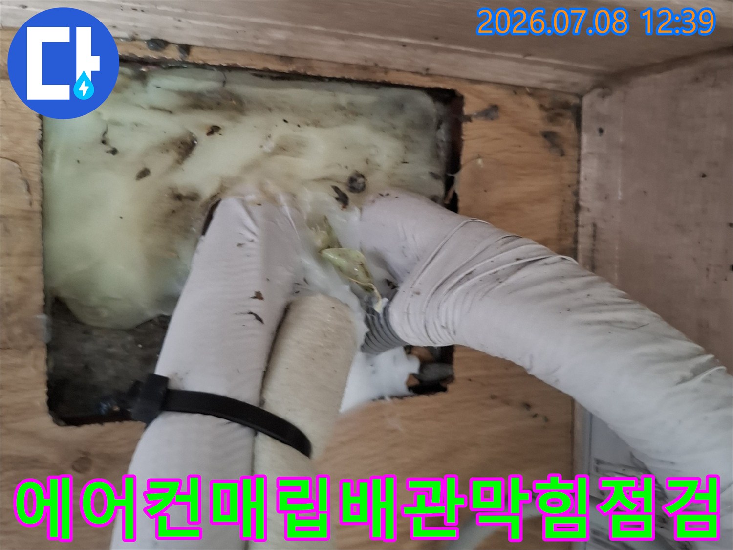 장갑을 낀 작업자가 오염된 에어컨 매립배관 연결 부위를 점검하는 모습