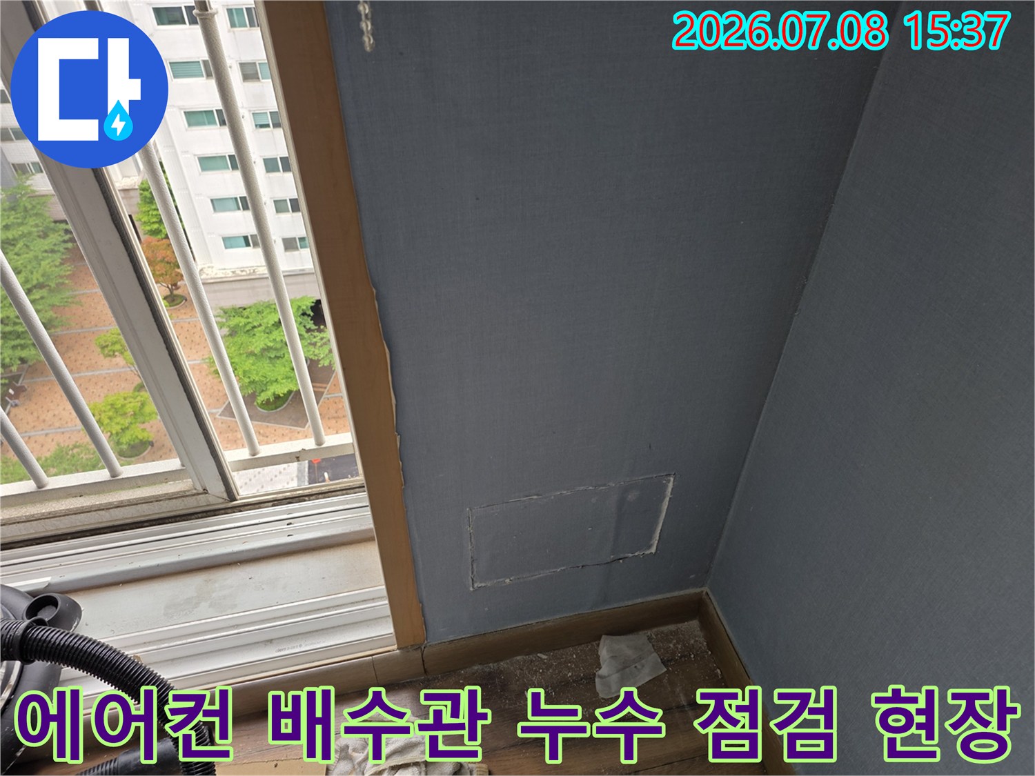 벽면을 절개하여 매립된 에어컨 배수관의 연결 부위를 세밀하게 점검하는 모습