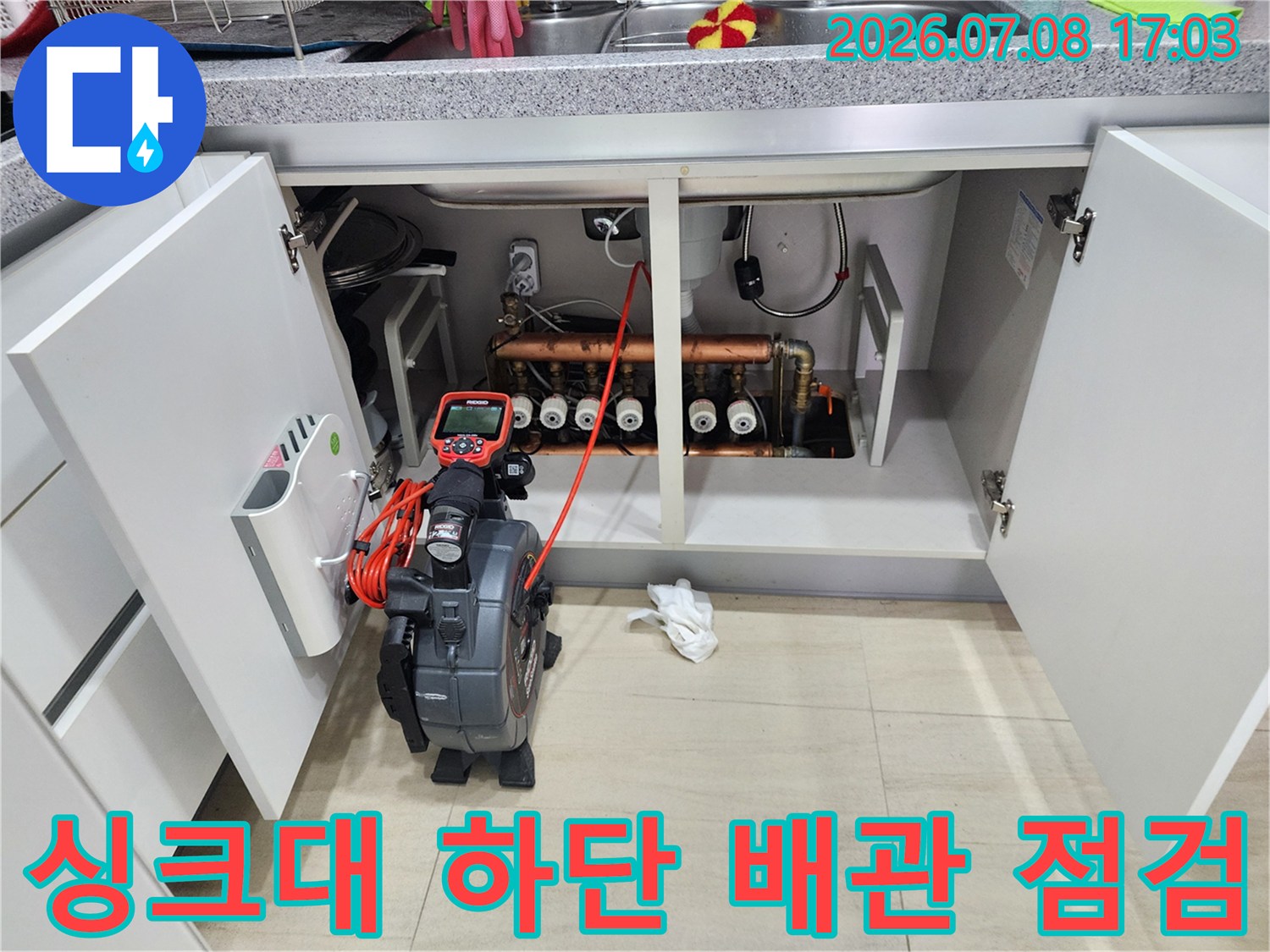 싱크대 밑 내부로 들어간 내시경 카메라와 복잡한 배관 구조의 모습