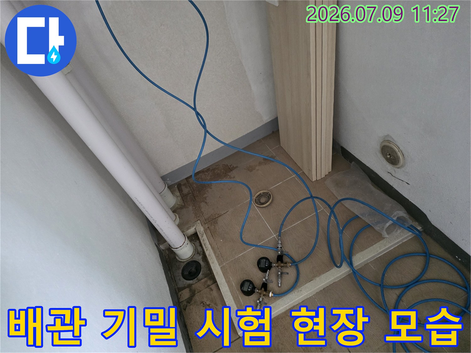 신규 배관 분배기 부근에서 파란색 호스를 연결하여 공압 점검을 진행하고 있는 사진입니다.