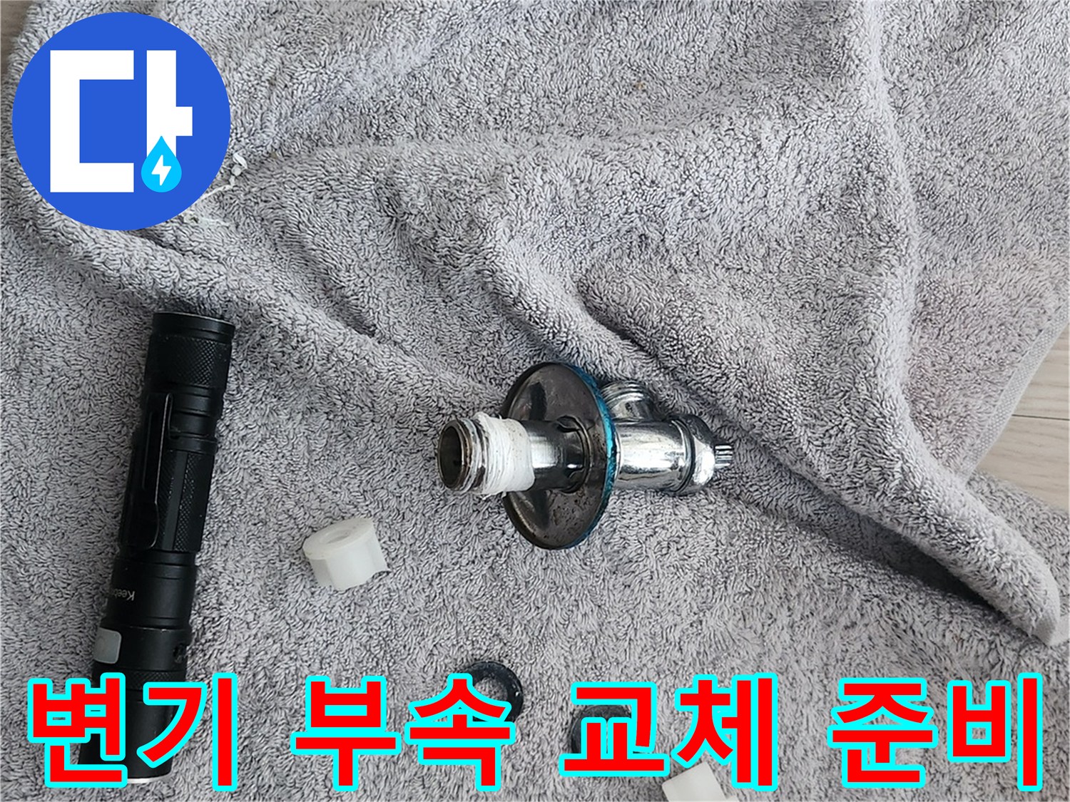 작업용 수건 위에 놓인 변기 밸브와 고무링 세트