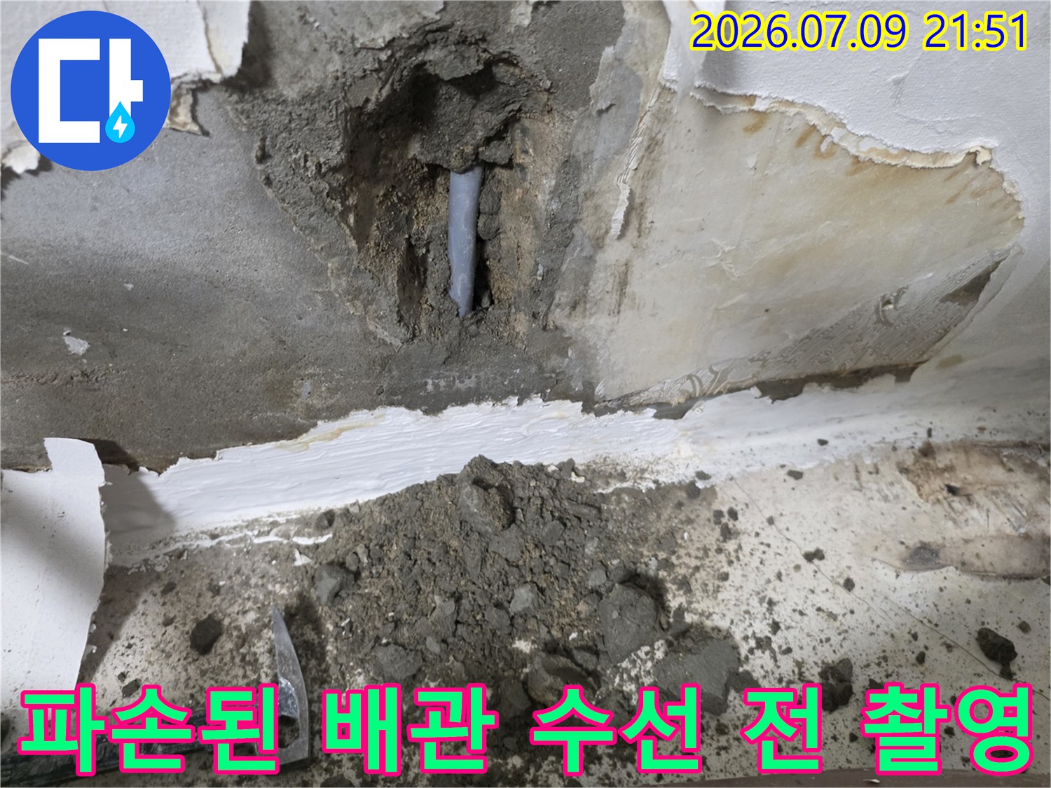 벽면 파쇄 후 노출된 배관의 손상 부위를 근접 촬영한 사진