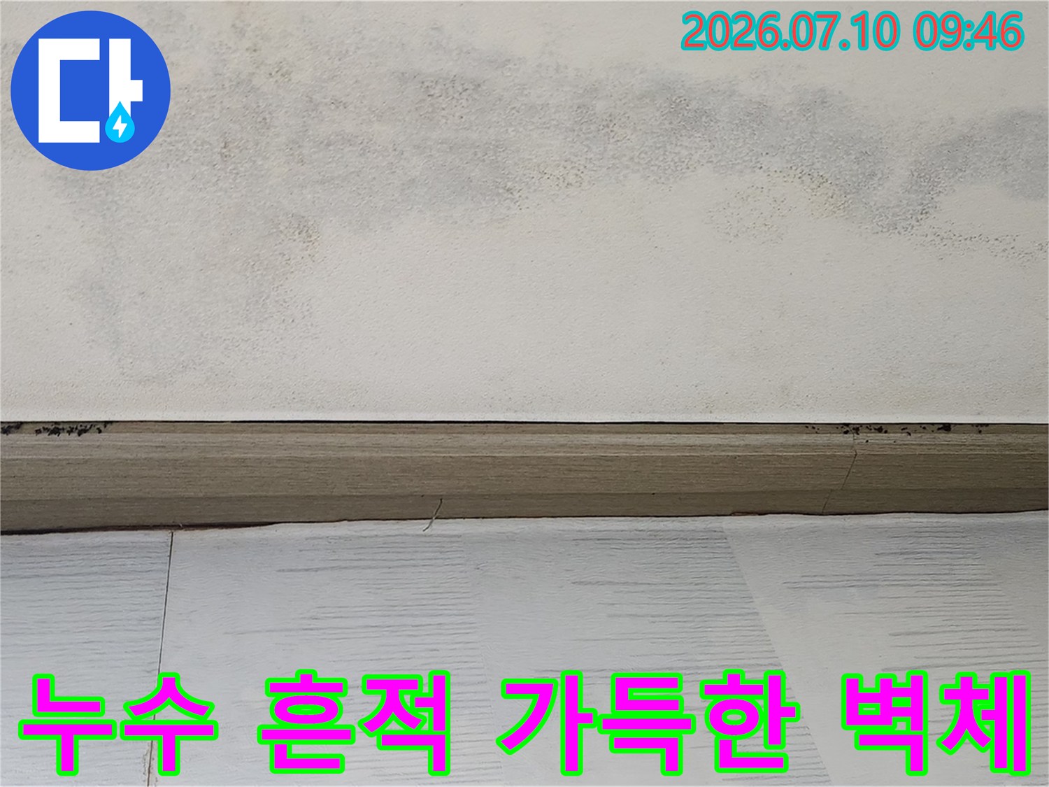 누수로 인해 변색된 천장 경계면과 오염된 벽지 확대 사진
