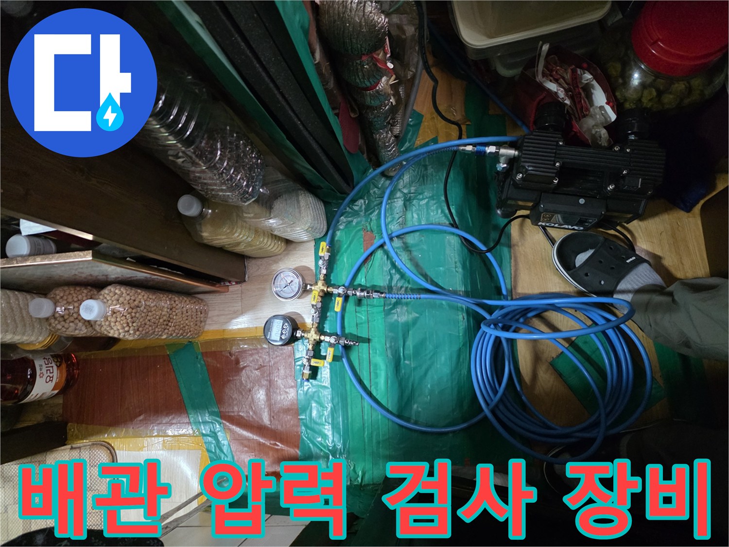 디지털 압력계와 파란색 호스가 연결된 배관 공압 테스트 현장 모습입니다.