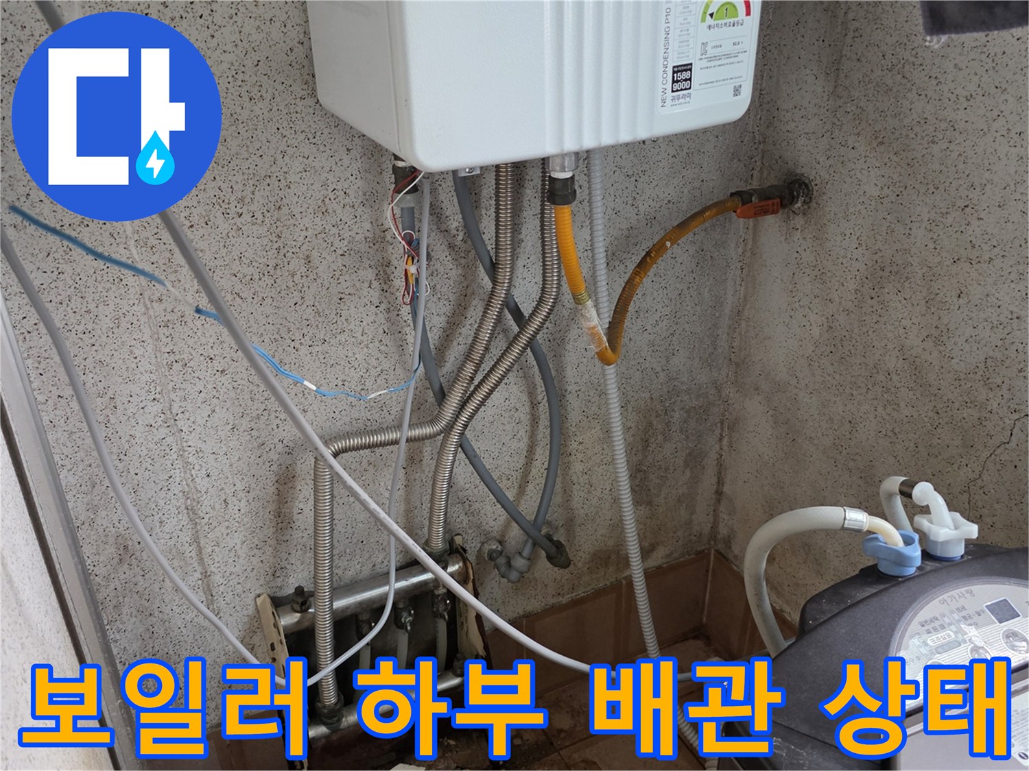 보일러 아래 연결된 다양한 규격의 배관과 세탁기 호스 모습