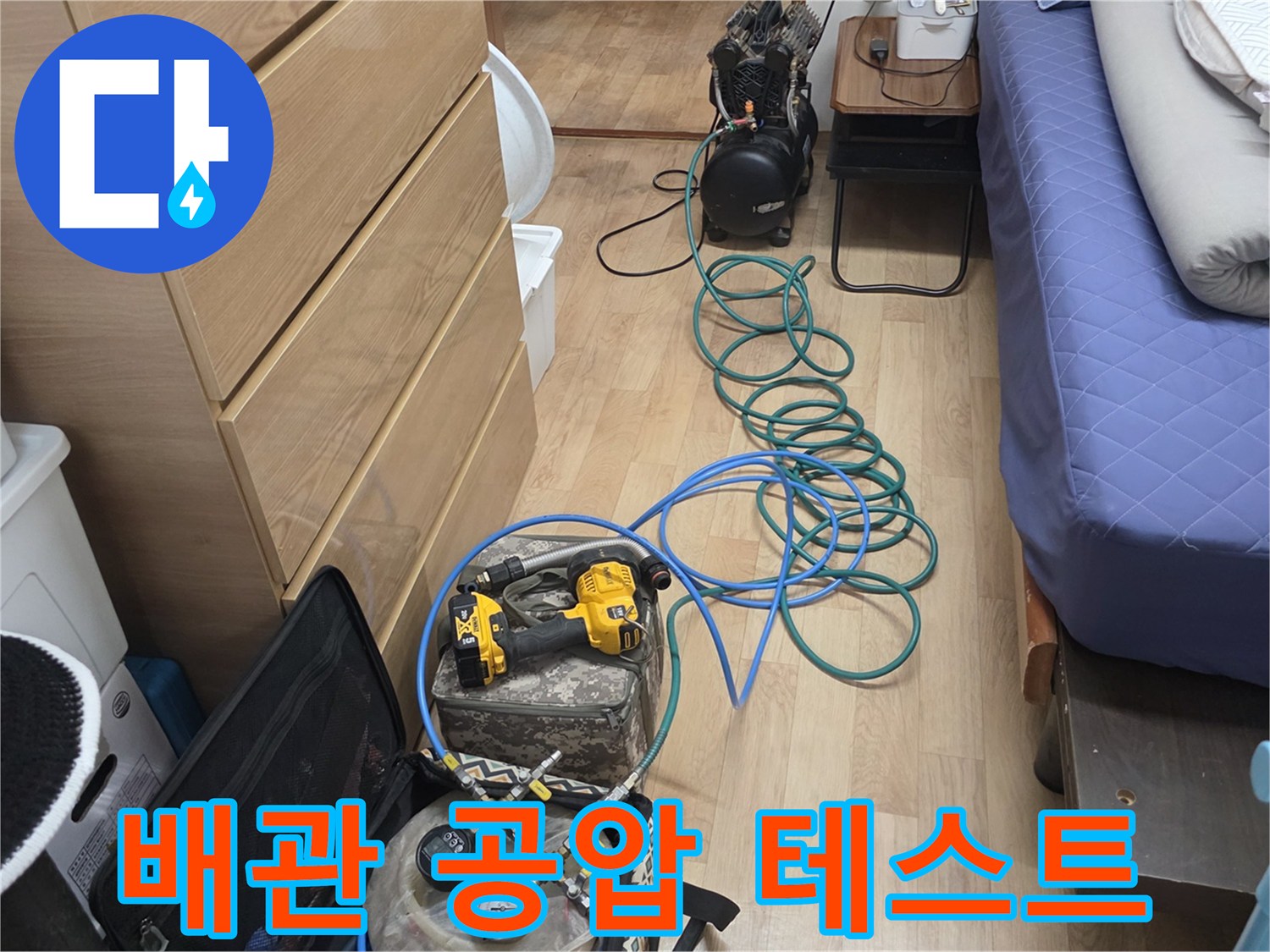 파란색 에어 호스와 디지털 압력 게이지가 연결된 현장 장비입니다.