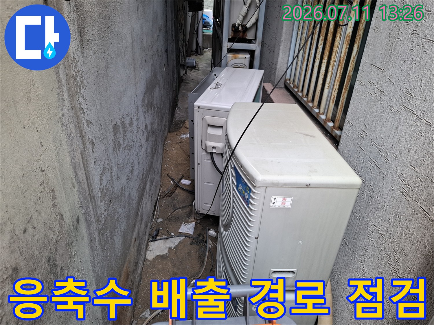 실외기실 내부에 설치된 여러 대의 실외기와 연결된 드레인관을 확인하는 모습