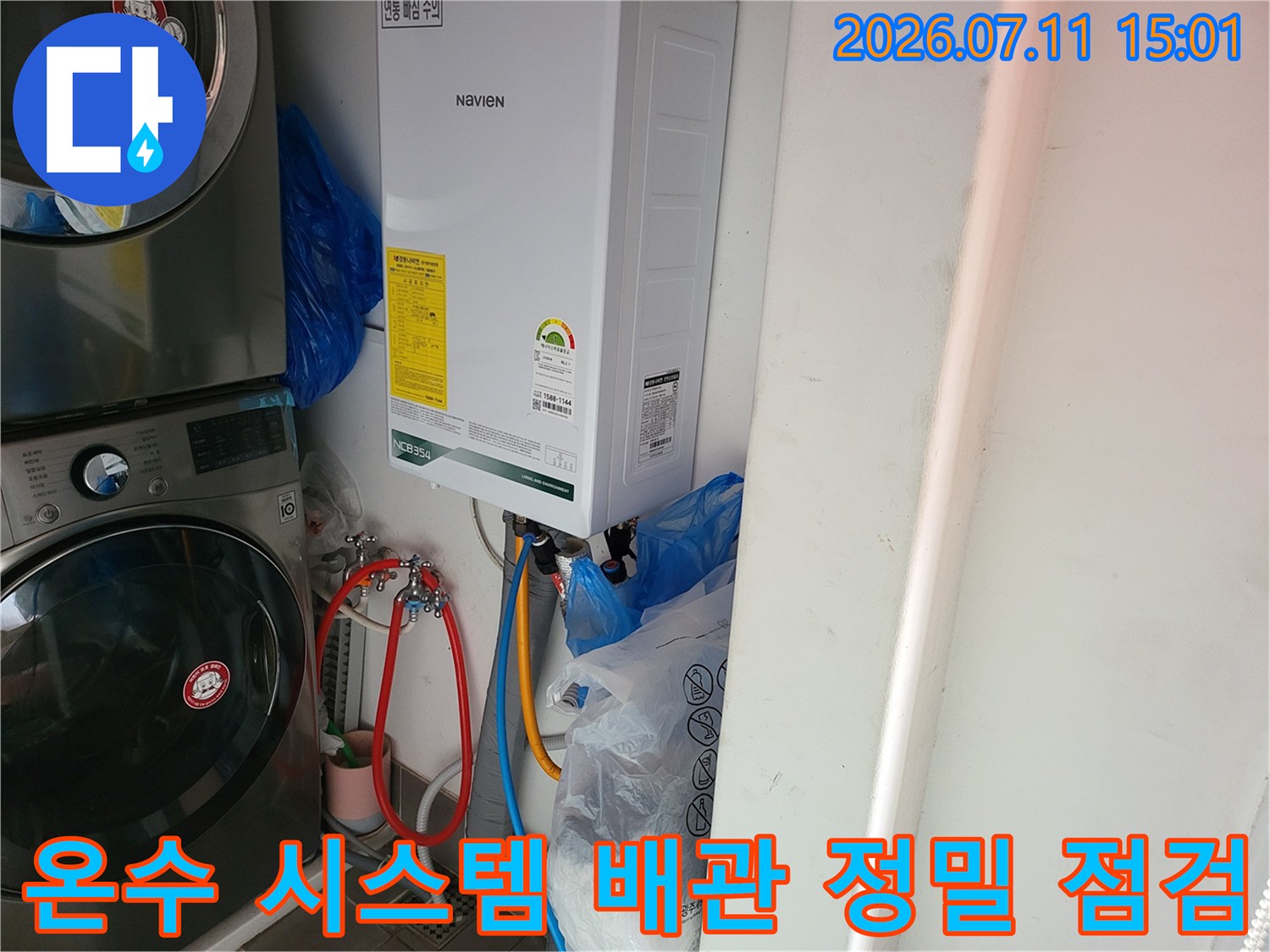세탁기 옆 온수기 하단부의 복잡한 배관과 탐지용 장치들