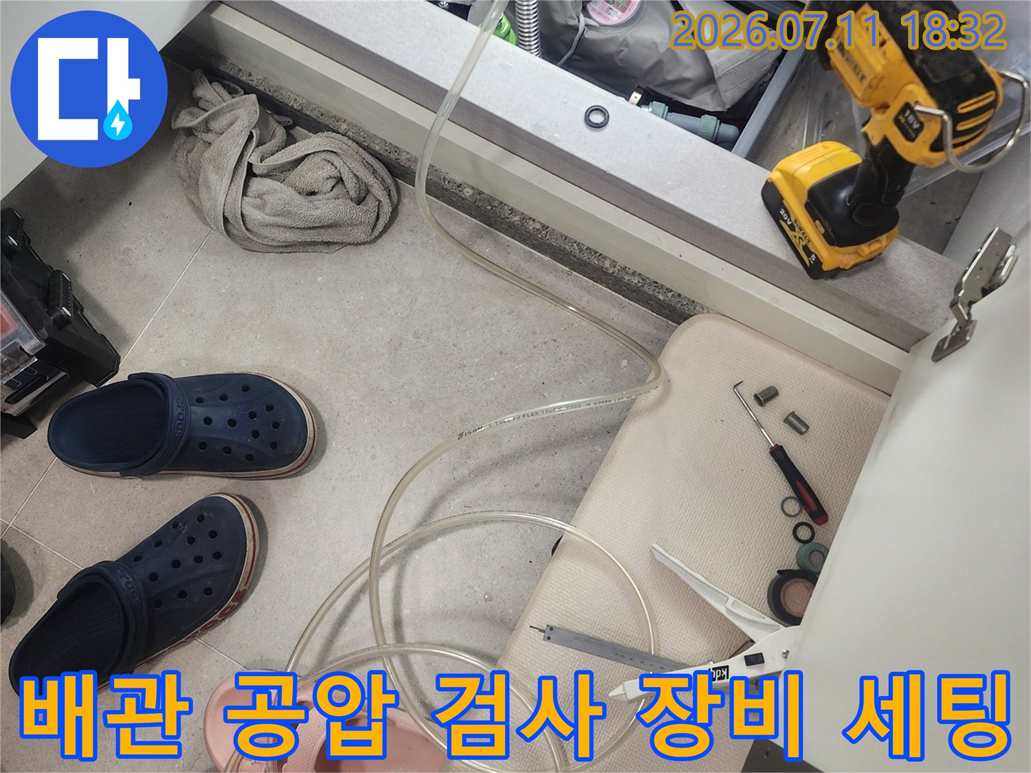 누수 점검을 위해 배관에 연결된 호스와 압력계가 있는 공압 검사 장면