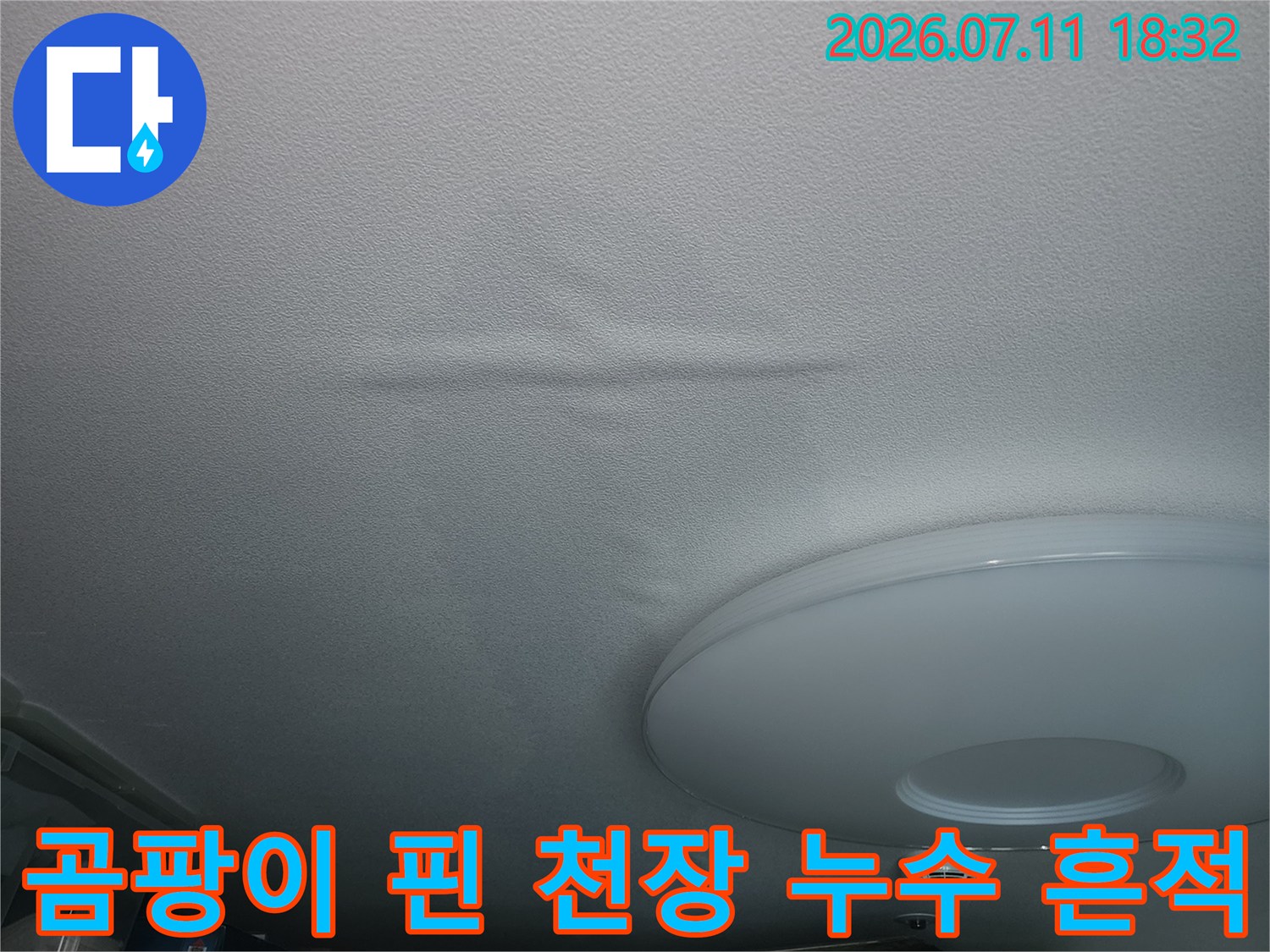 얼룩진 흰색 벽면에 발생한 세로형 누수 자국과 배관 관련 시설물