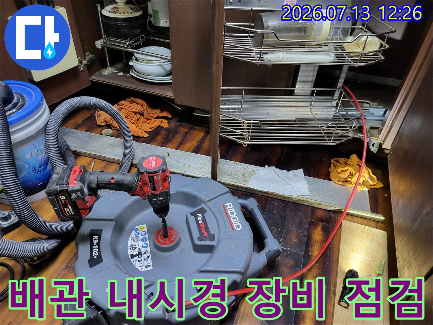 고성능 석션기와 내시경을 사용하여 싱크대 하부 배출 통로를 정밀하게 진찰하는 과정