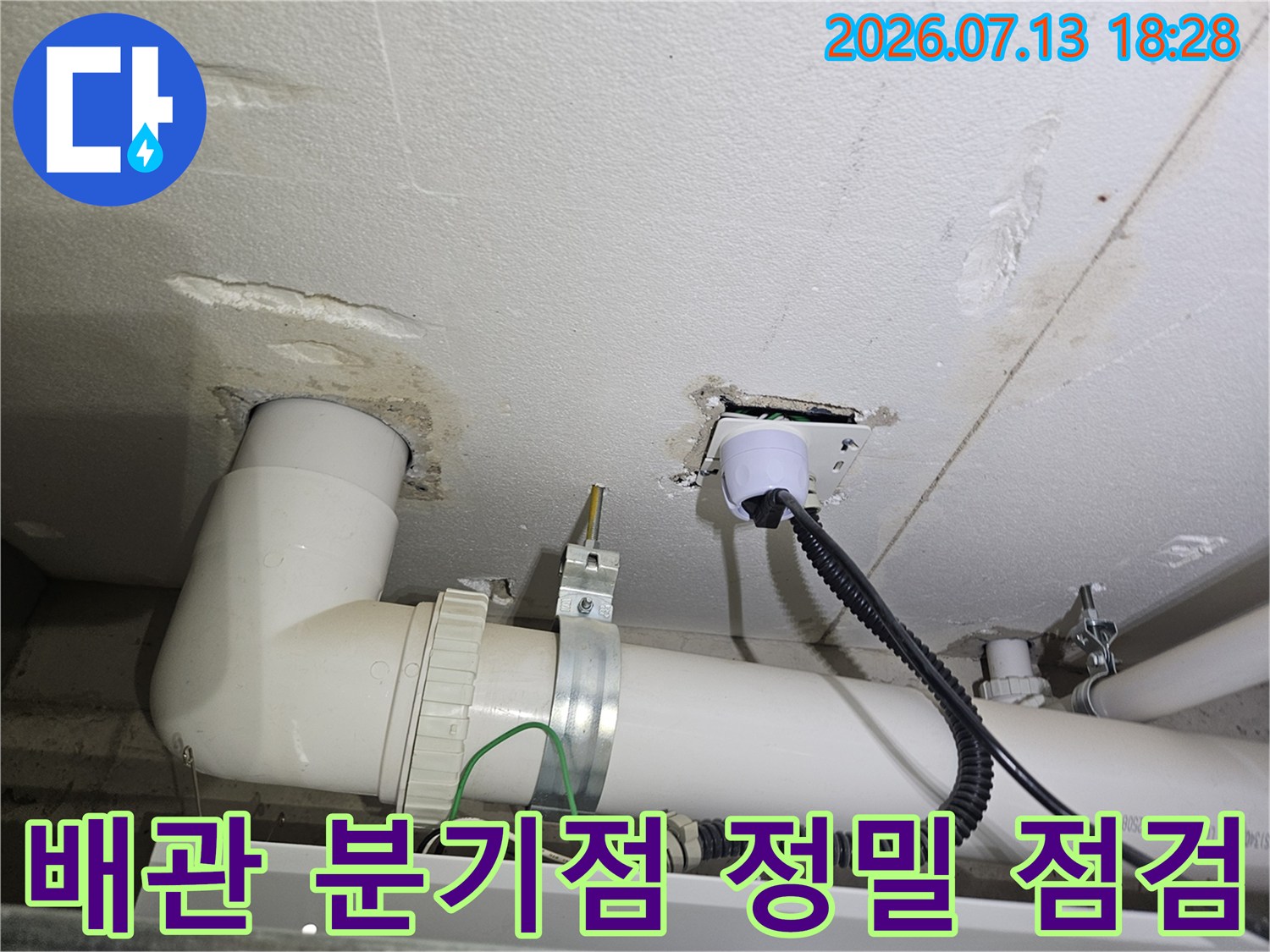 특수 진단 장비를 배관에 연결하여 누수 신호를 감지하며 세부 부위를 검사하는 장면입니다.