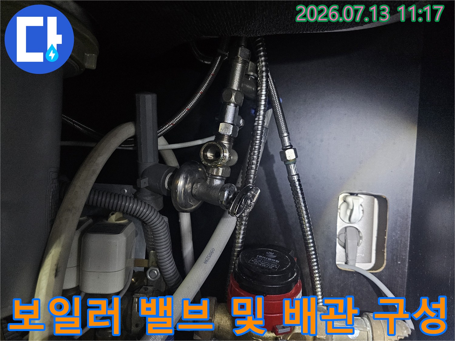 빨간색 핸들 밸브-스테인리스 호스-흰색 관이 복합적으로 연결된 하부 설비