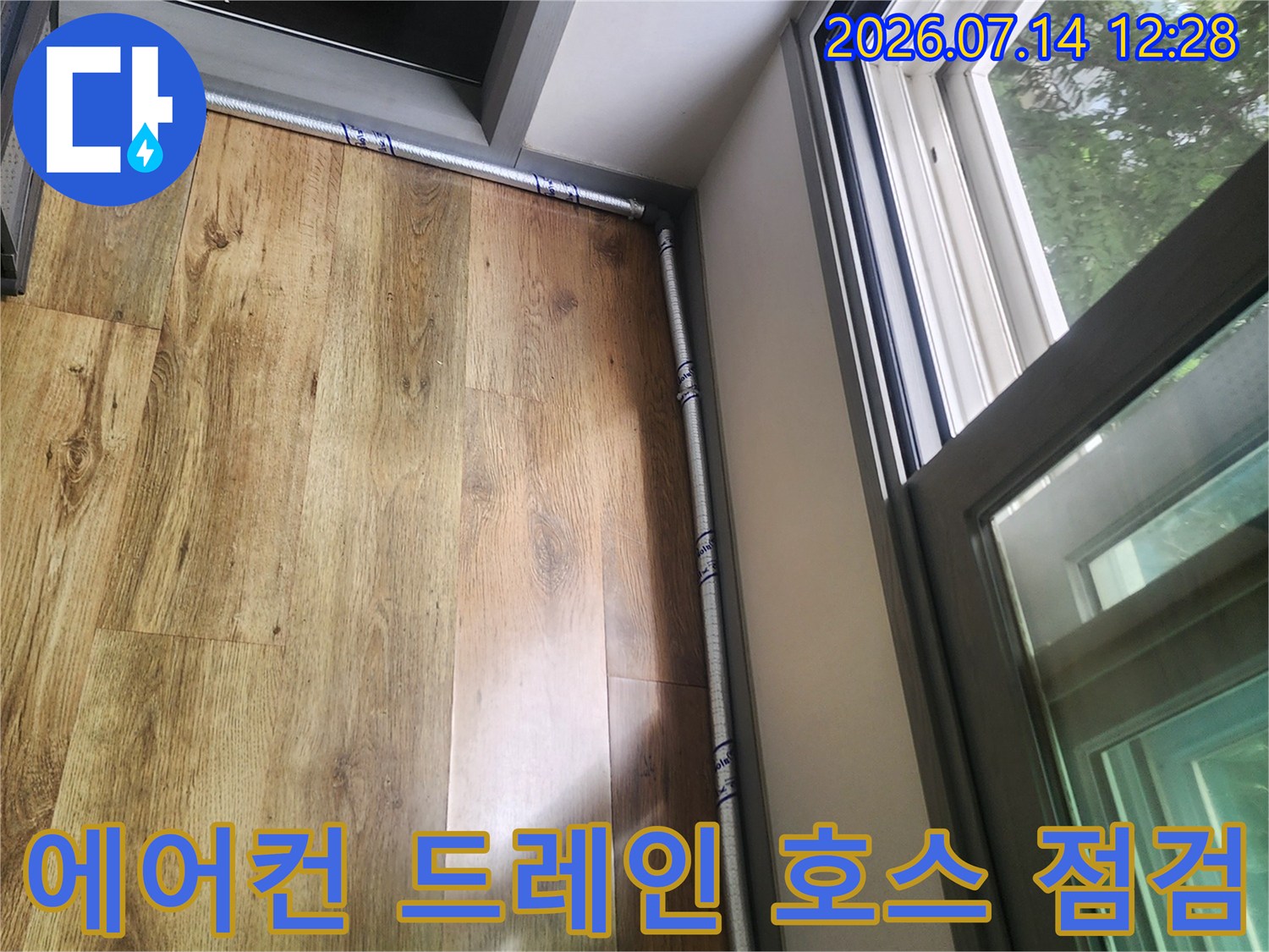 노출된 에어컨 배수 호스와 천장 목재 마감재의 결합 부위