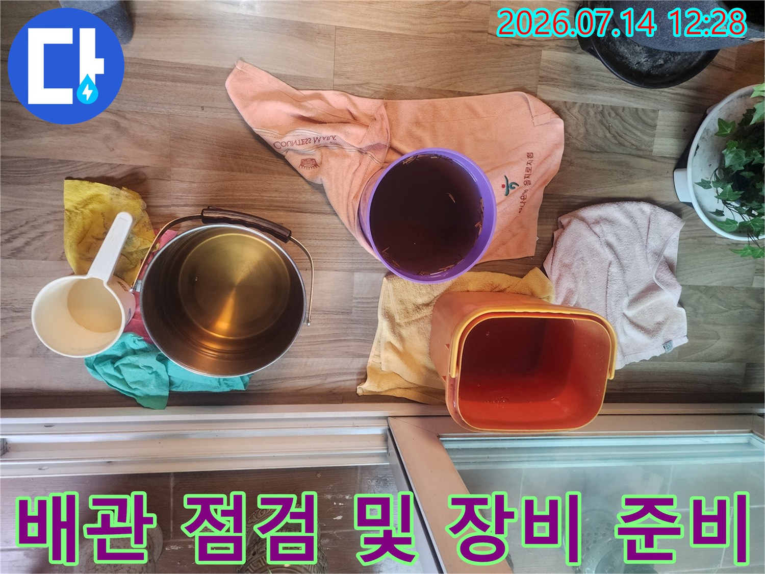 베란다 현장에서 누수 원인 파악을 위해 배관과 양동이 등 도구를 배치한 모습