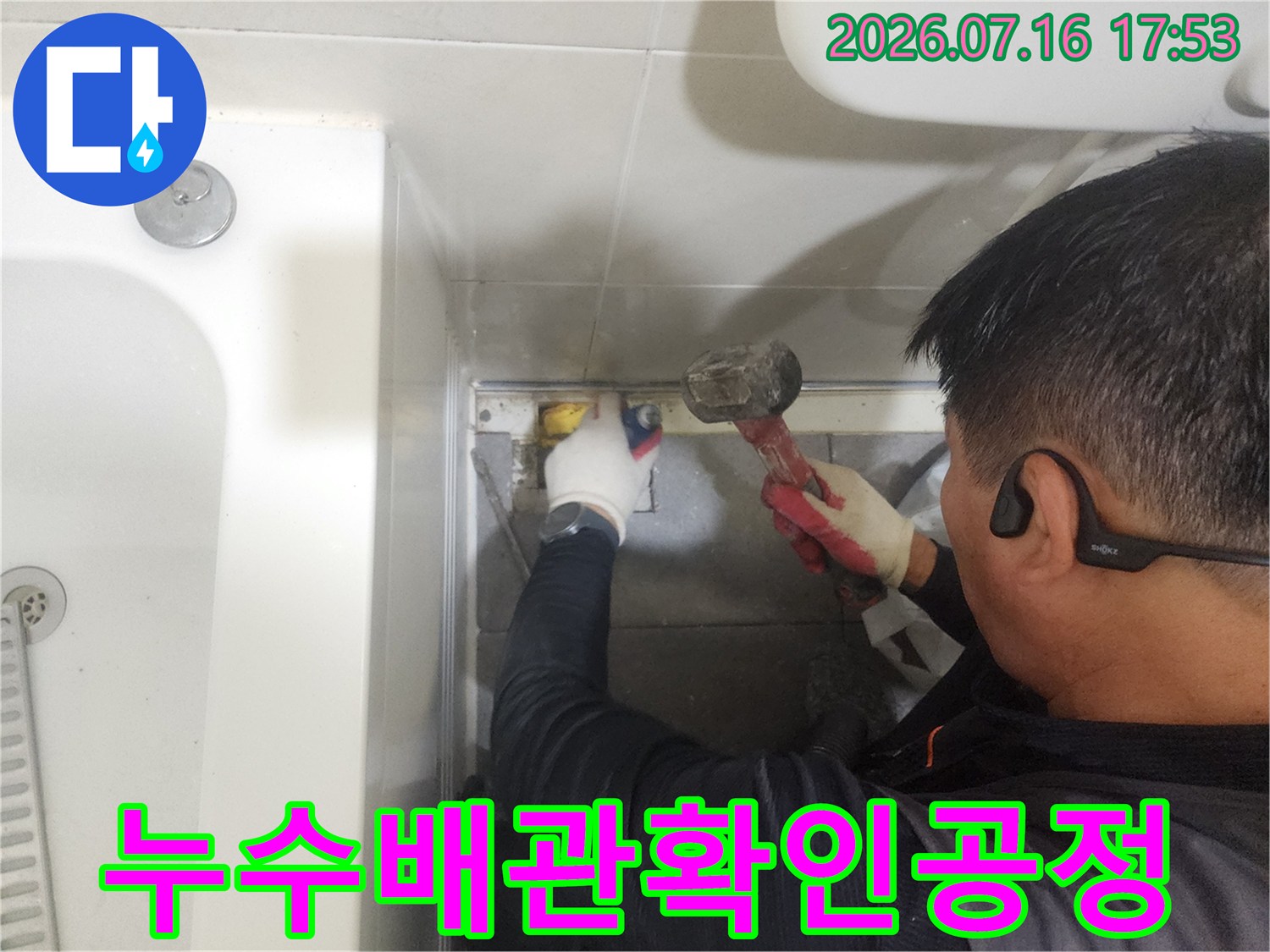 장갑을 낀 작업자가 공구로 노출된 배관 부위를 정밀하게 점검하는 모습