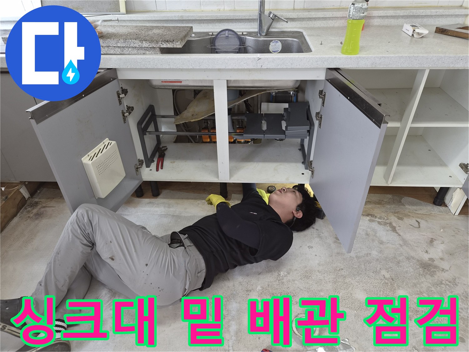 싱크대-하부장-공간에서-배관을-조사하는-기술자