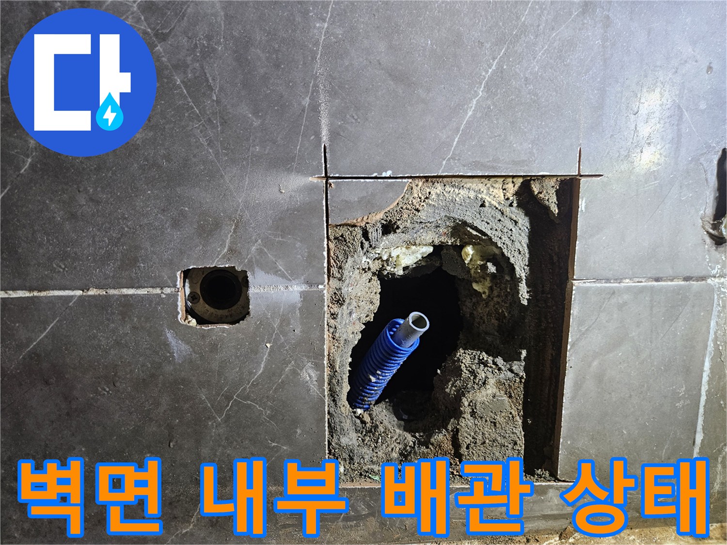 벽면 절개 부위 내부에 노출된 파란색 수도 배관