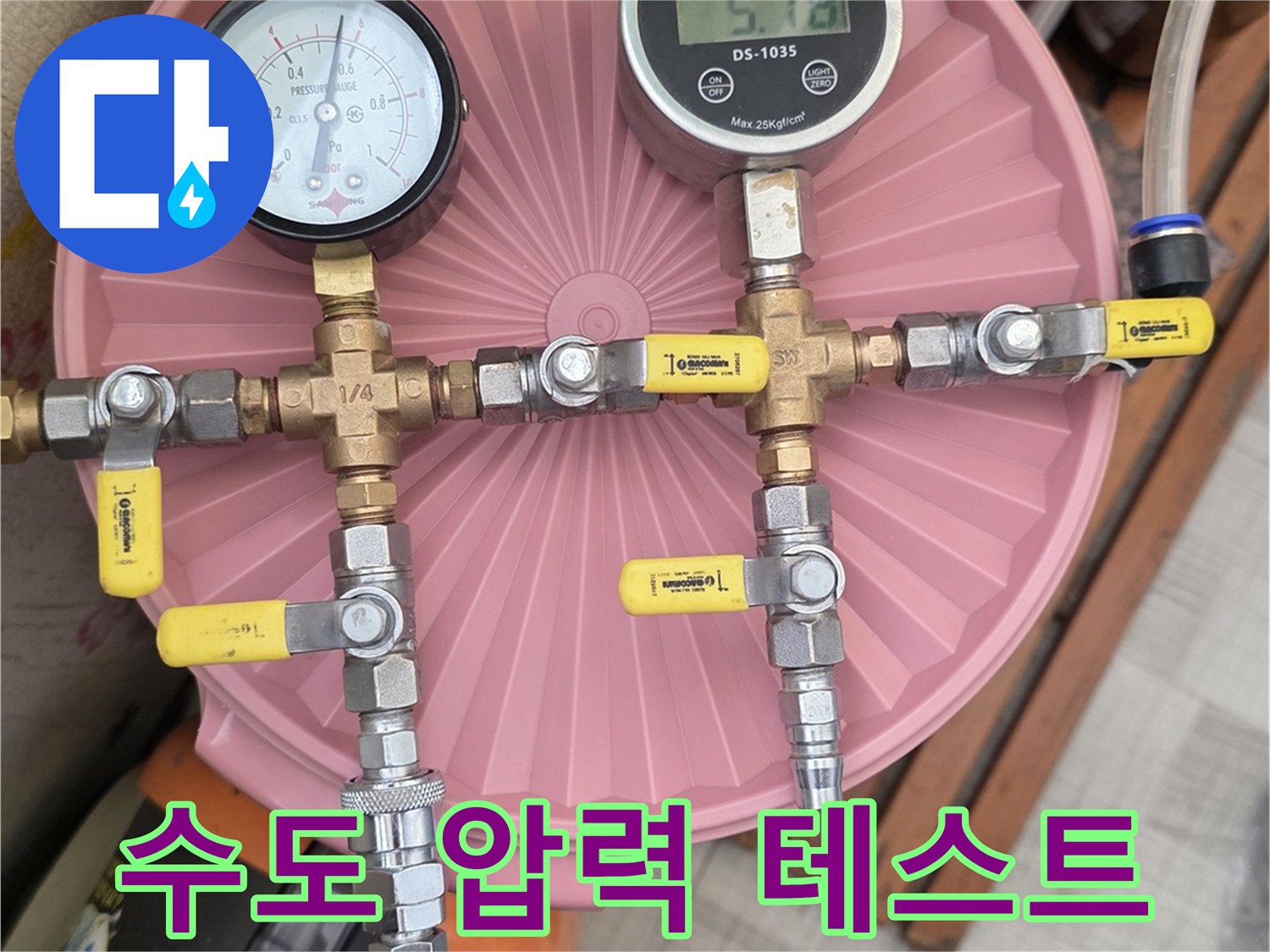 분홍색 덮개 위에 설치된 - 배관 압력 측정용 게이지와 호스 연결 상태