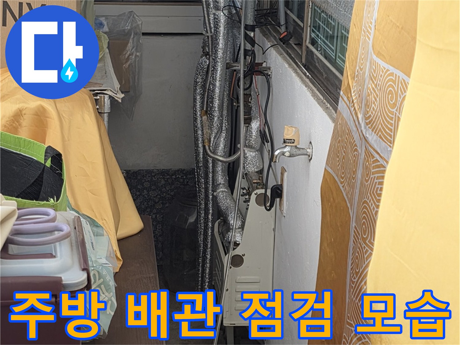 싱크대 하부장 내부의 수도 배관과 연결 부위를 정밀하게 검사하는 장면입니다.