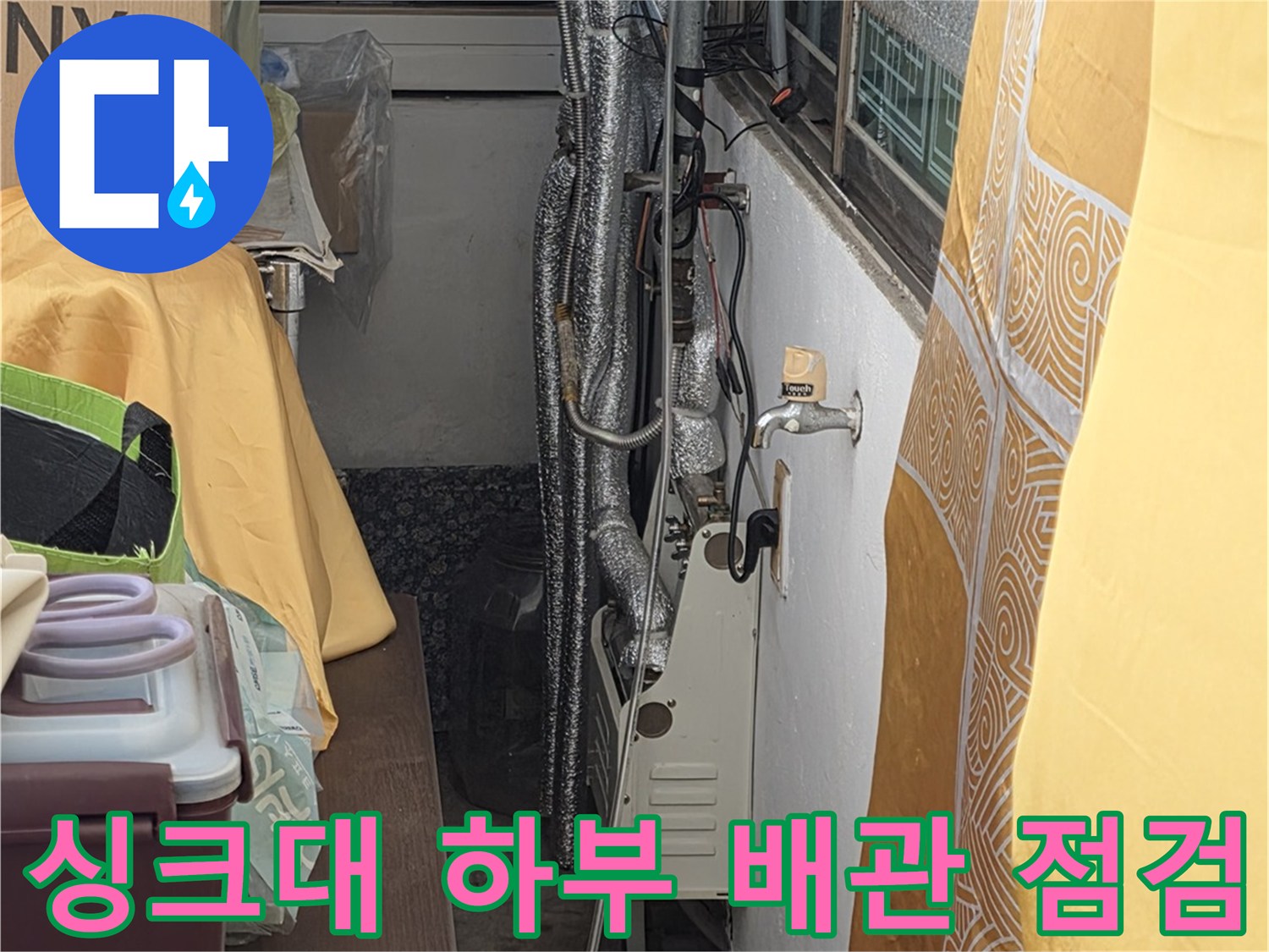 은색 보온재로 감싸진 싱크대 아래 수도 배관의 연결 상태 촬영