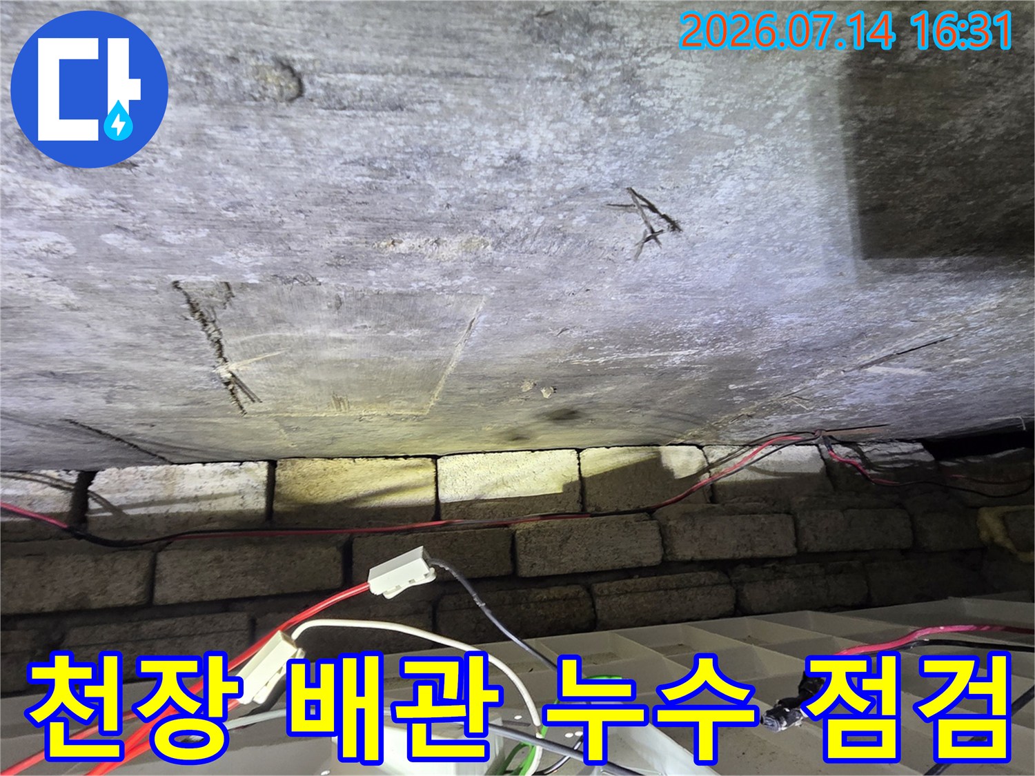 천장 내부 노출된 수도 배관에 압력 테스트 장치를 연결한 모습