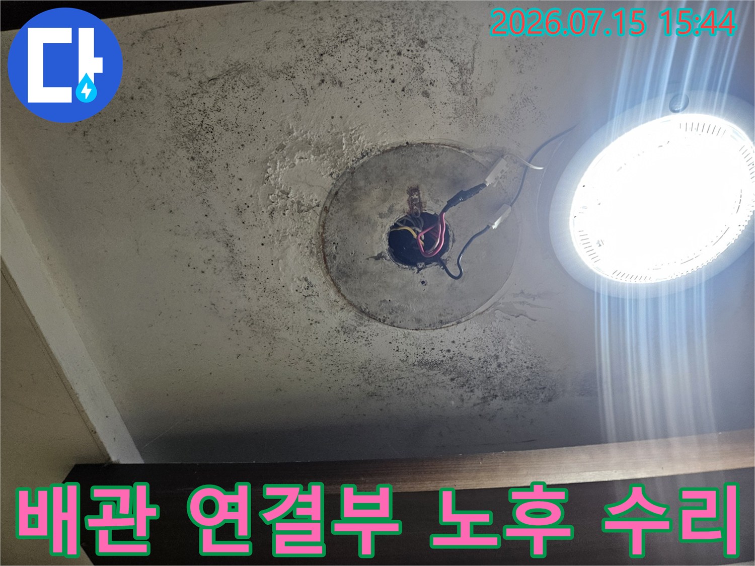 세면대 하단 배관이 노출된 상태에서 파손 부위를 보수한 장면