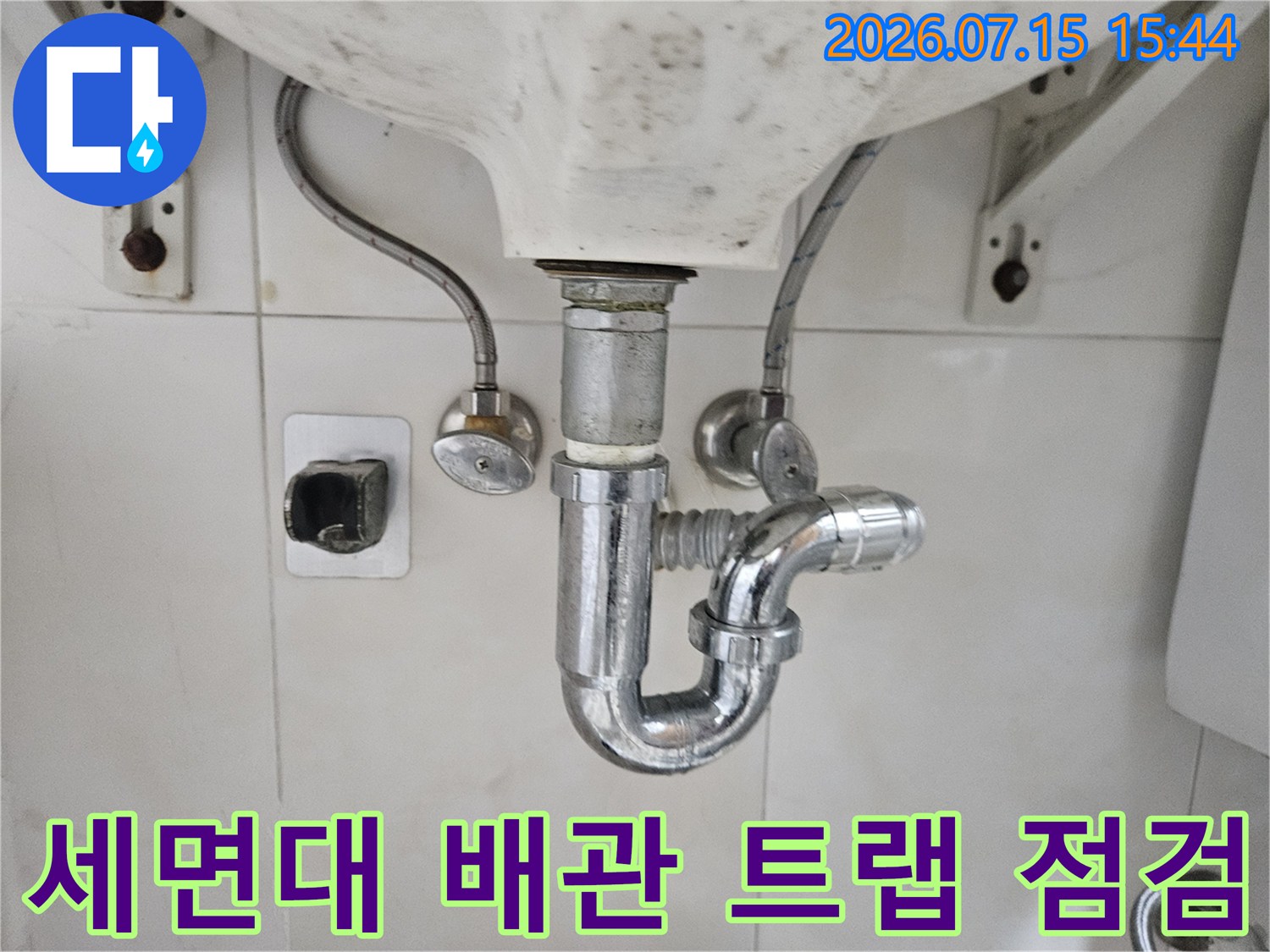 세면대 하부의 노출된 트랩과 수직/수평 연결 배관 상태 촬영