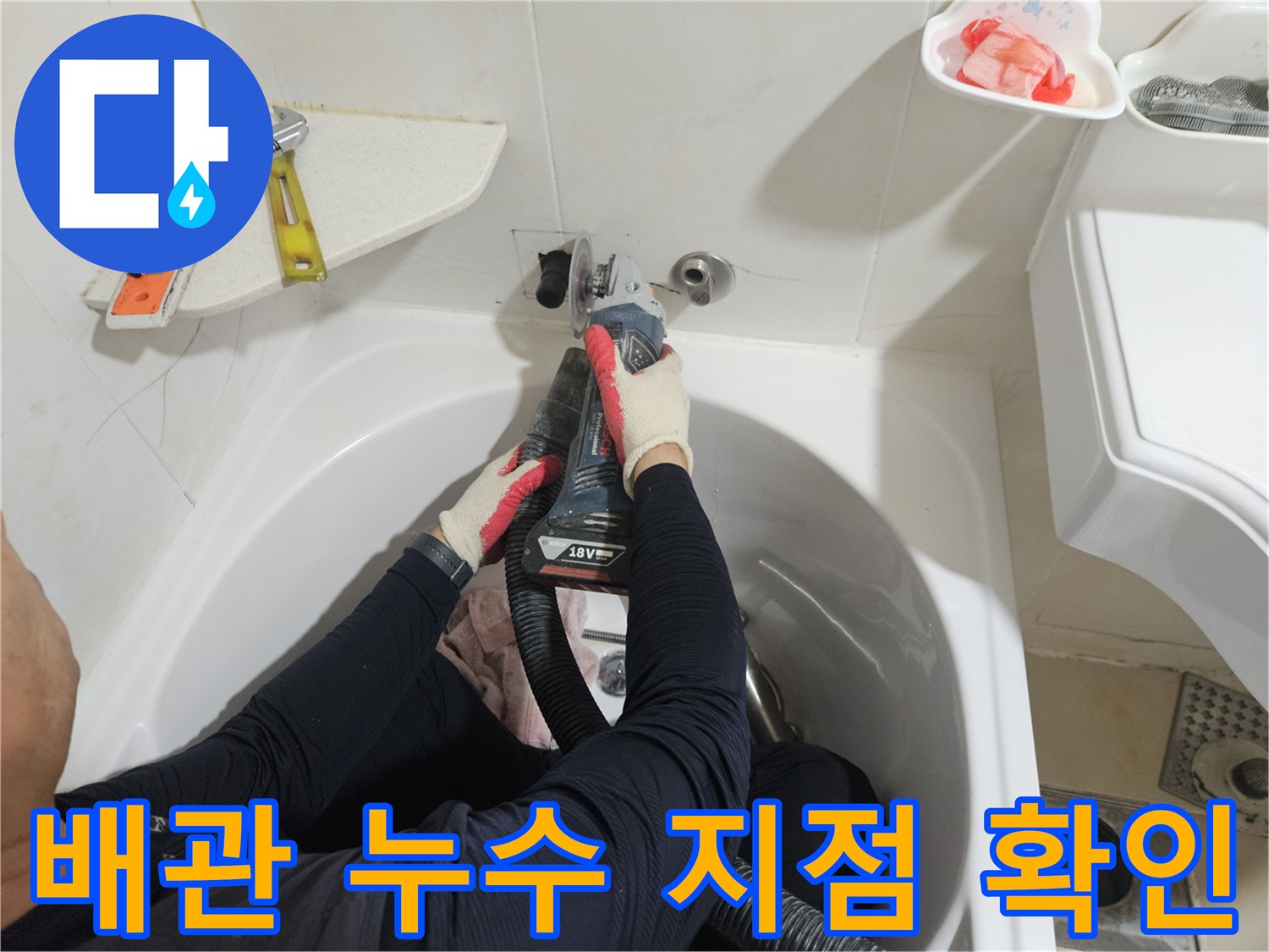 욕조와 벽면 경계의 배관 연결 상태를 정밀하게 조사하는 작업자