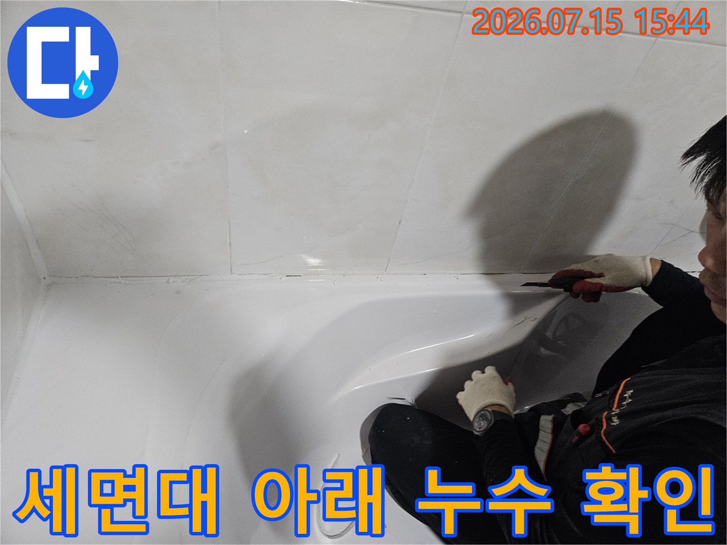 작업자가 세면대 하부 배관의 노후 상태를 꼼꼼히 점검하는 사진