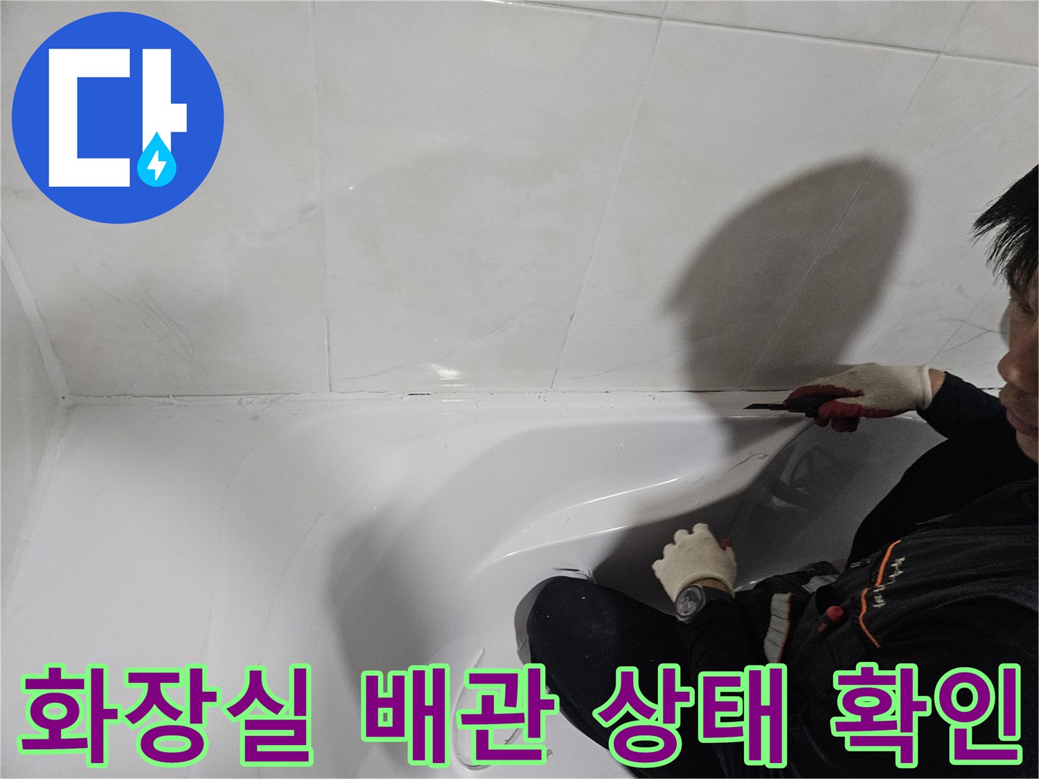 작업자가 욕조 하단 부위의-누수 지점을 점검하고 있습니다