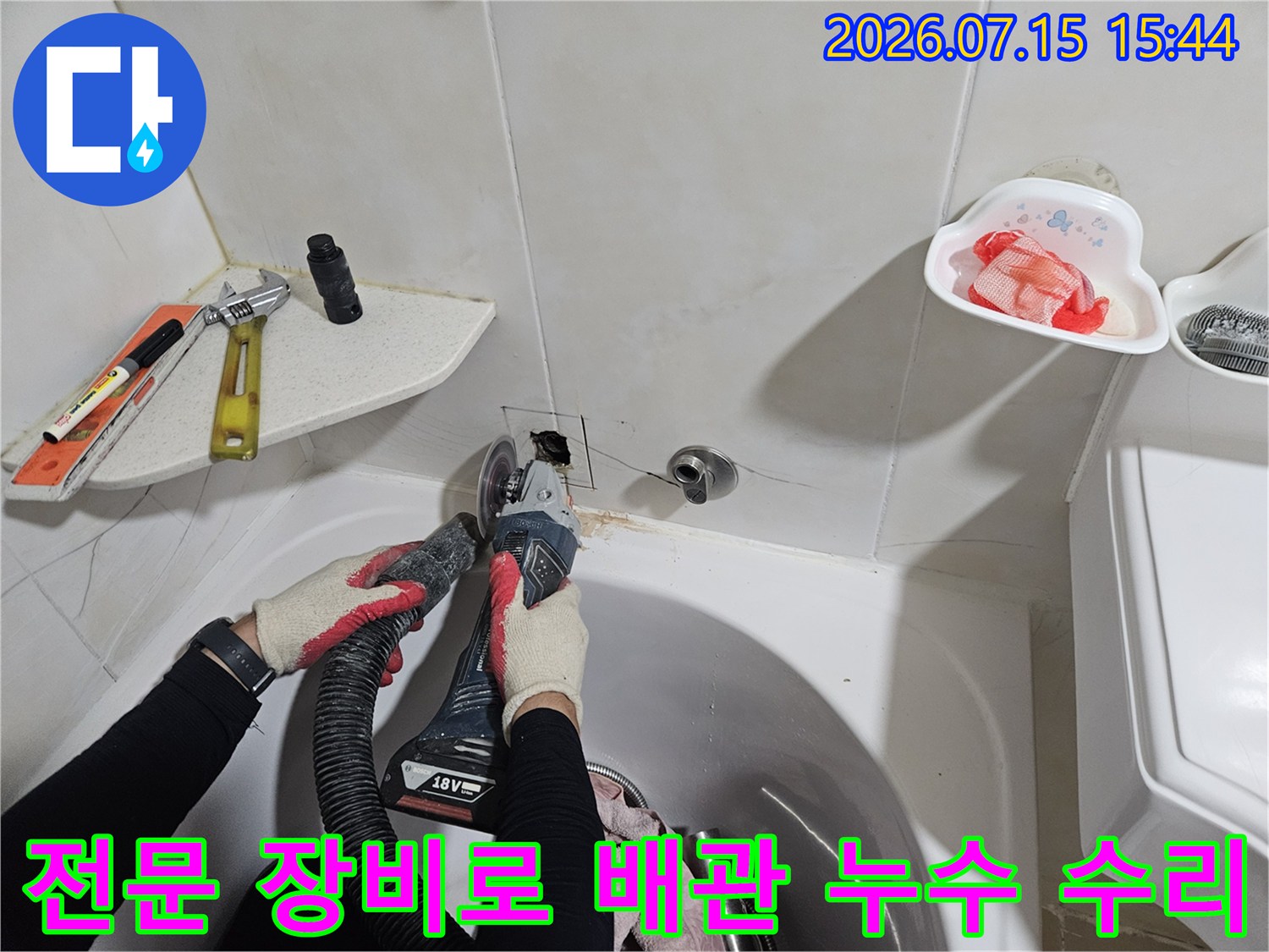 집진기와 전문 공구를 활용하여 세면대 아래 노출된 배관의 누수 지점을 처리하는 모습