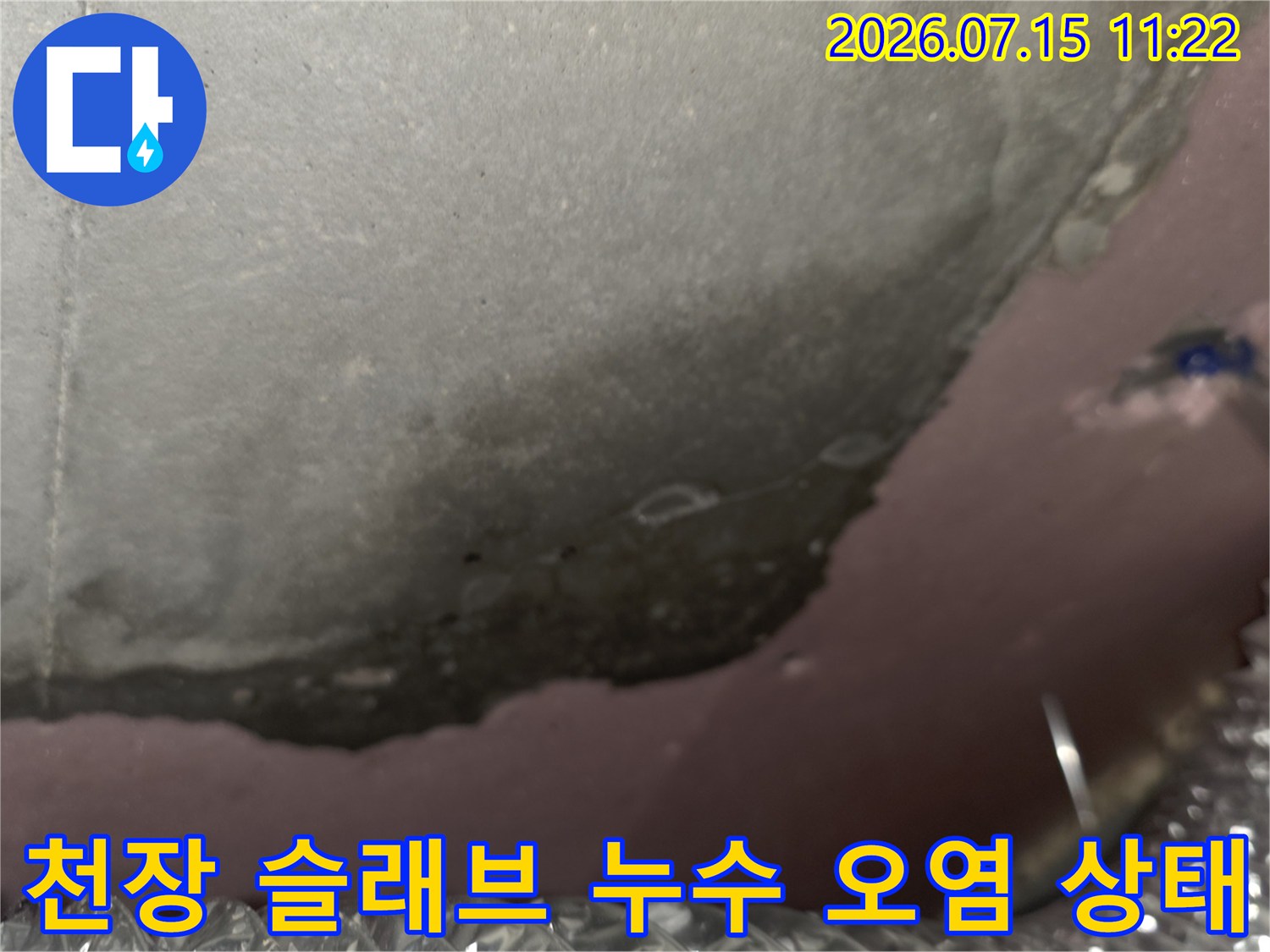 콘크리트 천장에 발생한 짙은 갈색과 회색의 누수-오염 얼룩