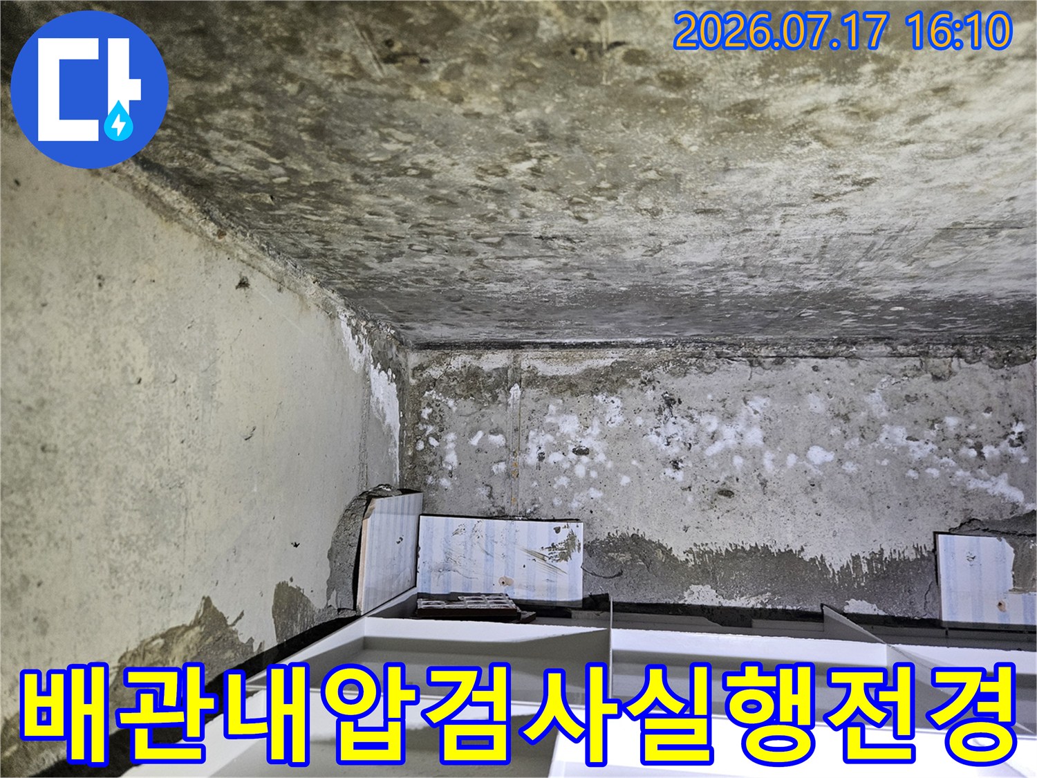 화장실 내부로 들어온 배관들에 압력 게이지를 연결하여 공기압 테스트 중인 장면