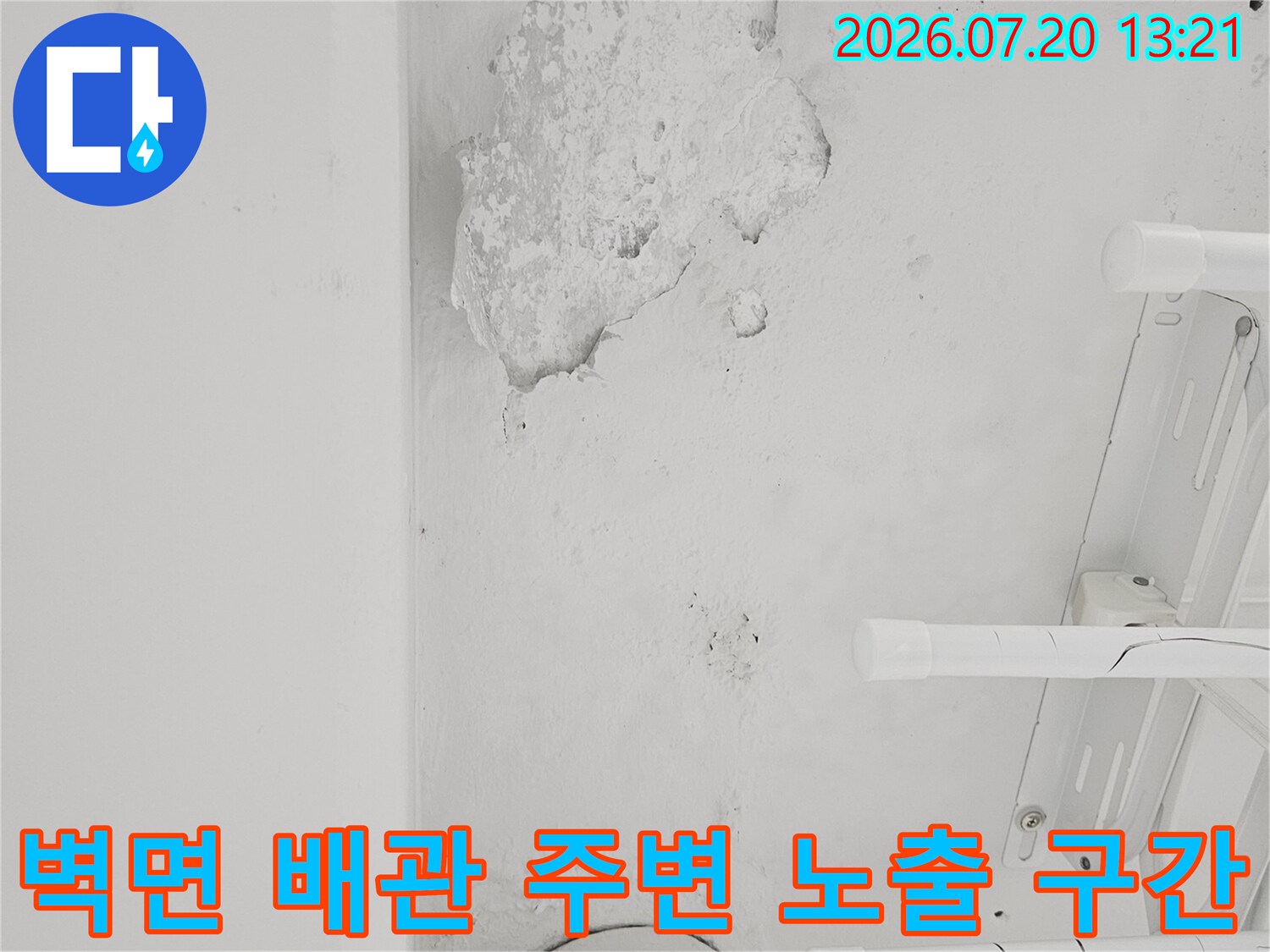 배관과 벽이 만나는 지점의 파손된 마감재와 콘크리트 영역