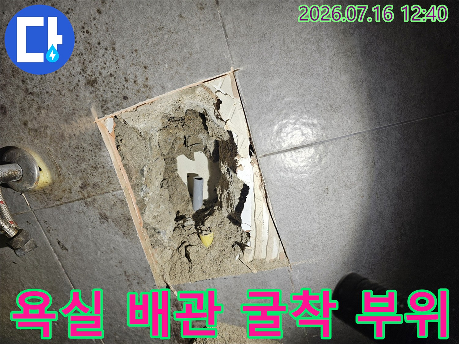 타일을 제거하고 노출된 욕실 내 배관 파손 지점의 모습