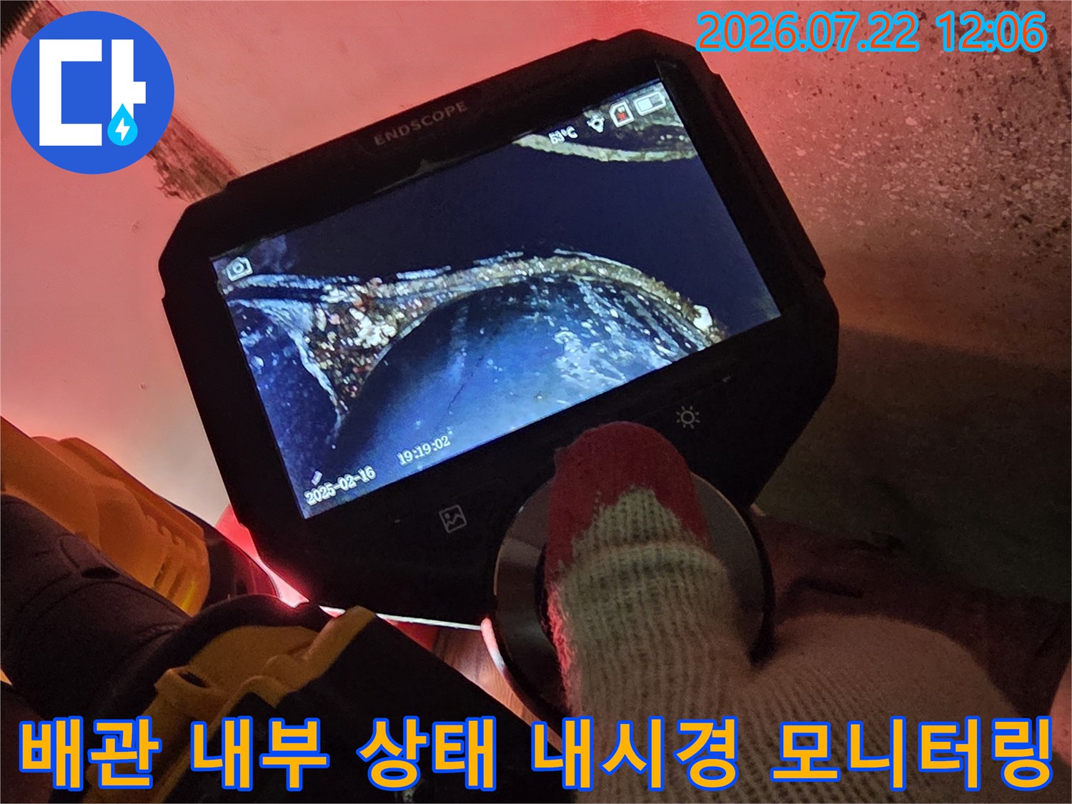 손에 쥔 휴대용 내시경 모니터를 통해 배관 내부의 오염물질과 누수 지점을 세밀하게 확인하는 모습