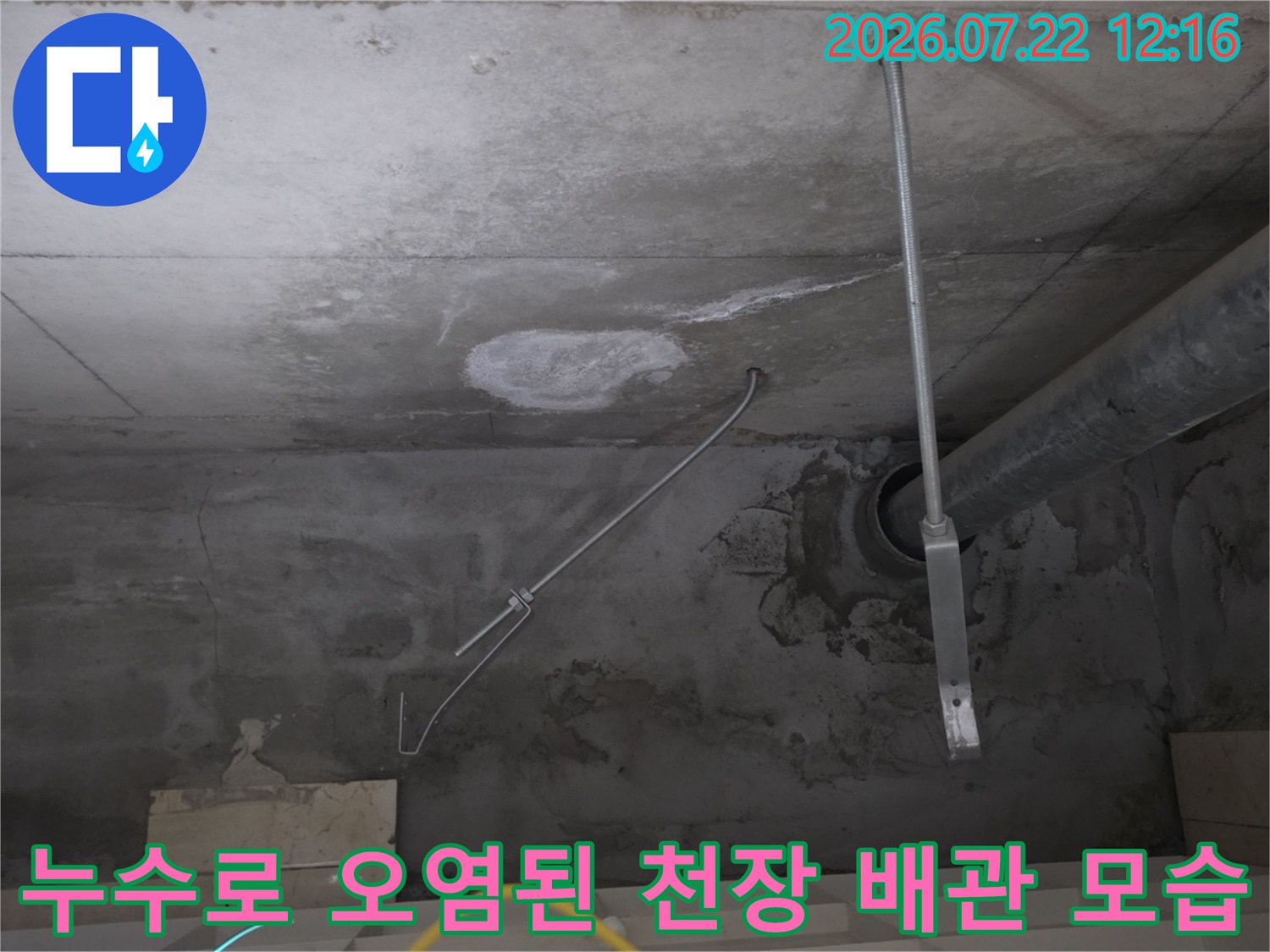 콘크리트 천장에 설치된 금속 배관과 그 주변의 누수 흔적-물자국