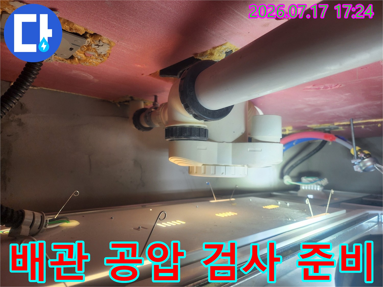 누수 여부를 판단하기 위해 천장 배관과 연결된 장비로 정밀 압력 테스트를 수행하는 모습