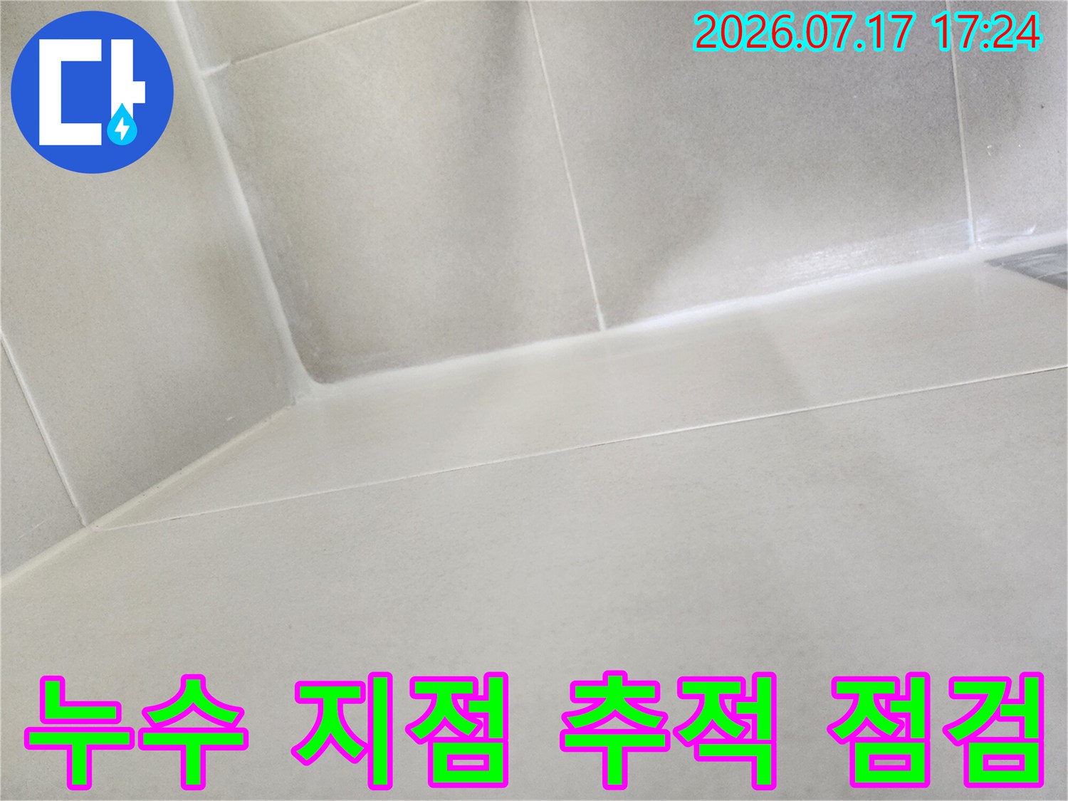 화장실 천장 아래쪽과 벽면의 경계 부분을 조사하여 누수 경로를 파악하는 과정