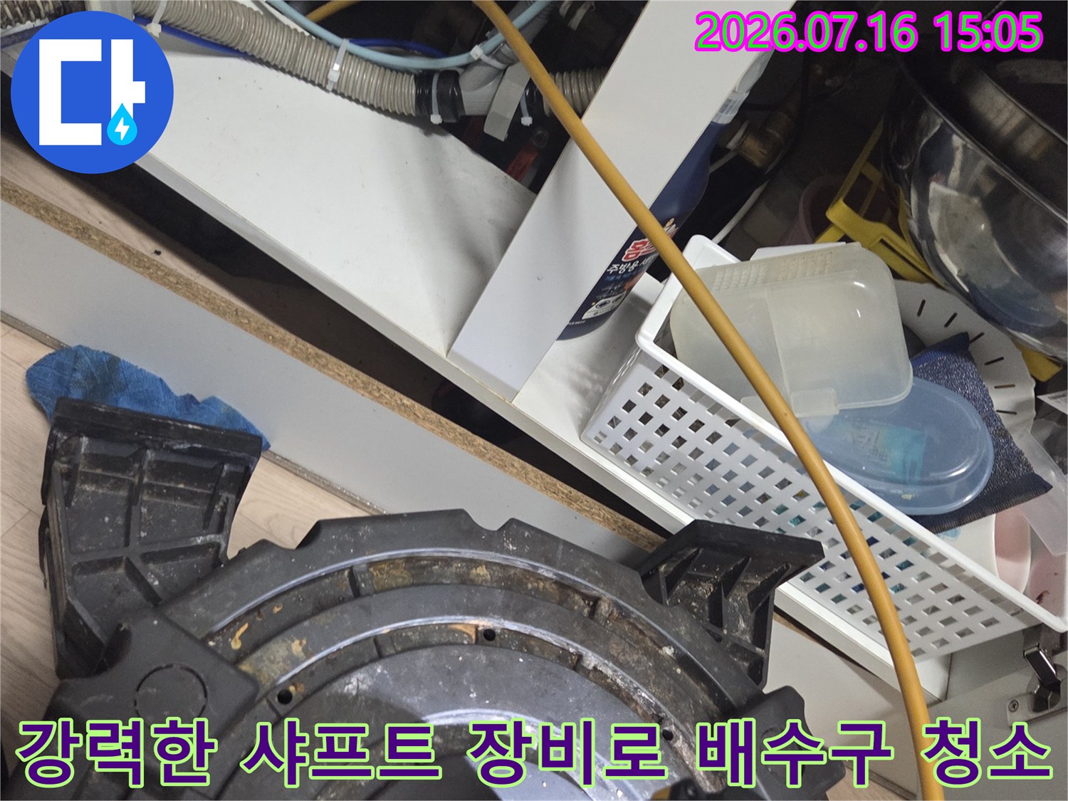 싱크대 아래 구간에서 플렉스 샤프트를 사용하여 배관 내부 찌꺼기를 파쇄하는 장면